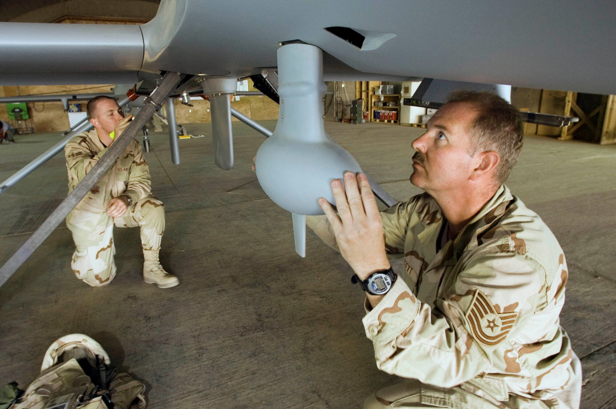 BALAD AIR BASE, Iraq (AFPN) - Tech. Sgt. James Moffett (right) and Airman 1st Class Dathen Schori inspect an unmanned aerial vehicle. Sergeant Moffett is a UAV crew chief and Airman Schori is an avionics specialist with the 332nd Expeditionary Aircraft Maintenance Squadron's Aircraft Maintenance Unit. (U.S. Air Force photo by Master Sgt. John E. Lasky)