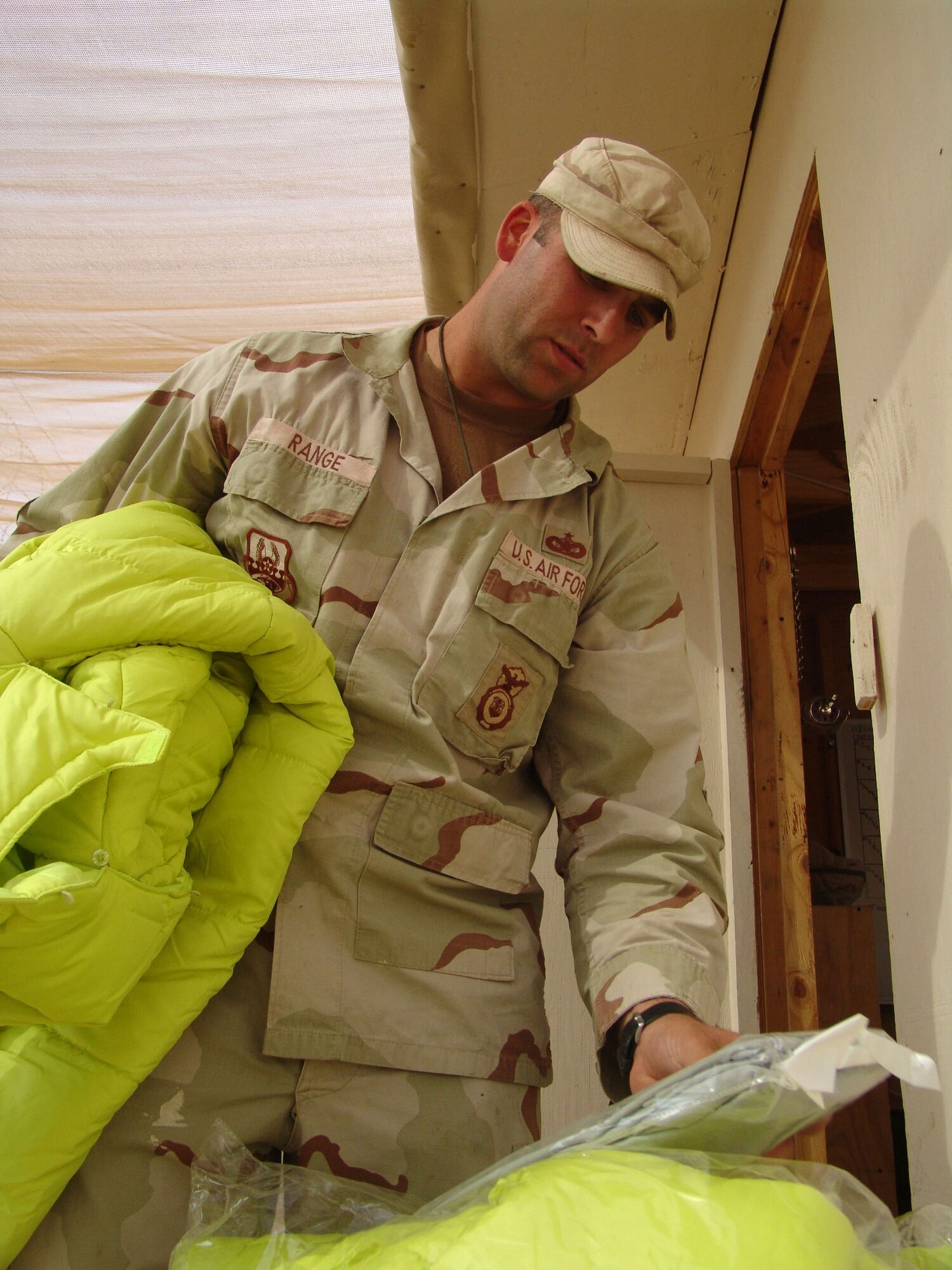 CAMP BUCCA, Iraq (AFPN) -- Staff Sgt. Kevin Range, a 586th Expeditionary Security Forces Squadron security forces member, sorts winter jackets for detainees in the theater internment facility. The 586th ESFS provides base and area security and convoy escorts here. (U.S. Air Force photo by Capt. Michael G. Johnson)