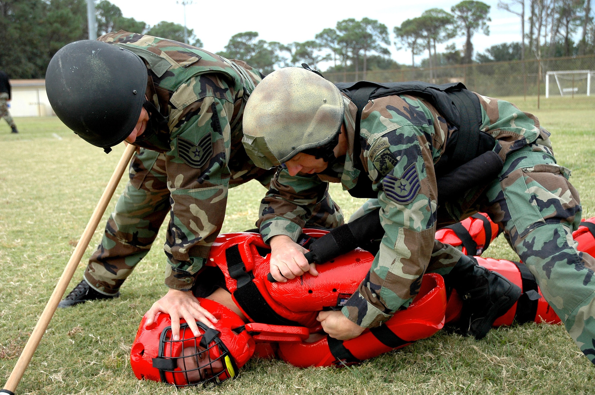 HURLBURT FIELD, Fla. -- A combat aviation advisor and an enlisted terminal attack controller practice subduing an attacker who attempted to disarm them. Working together, the two battlefield Airmen use enhanced pain techniques to control the assailant without doing permanent harm. (U.S. Air Force photo by Capt. Tom Montgomery)