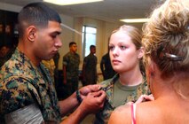 As a lance corporal in 2005, Victor Perez pins corporal rank insignia on his wife Cpl. Kara Perez during her promotion ceremony at Marine Corps Recruit Depot Parris Island, S.C. Although Kara no longer out ranks her husband, Victor still calls her his "Sugar Mama" because her financial entitlements give her the larger paycheck of the two sergeants.