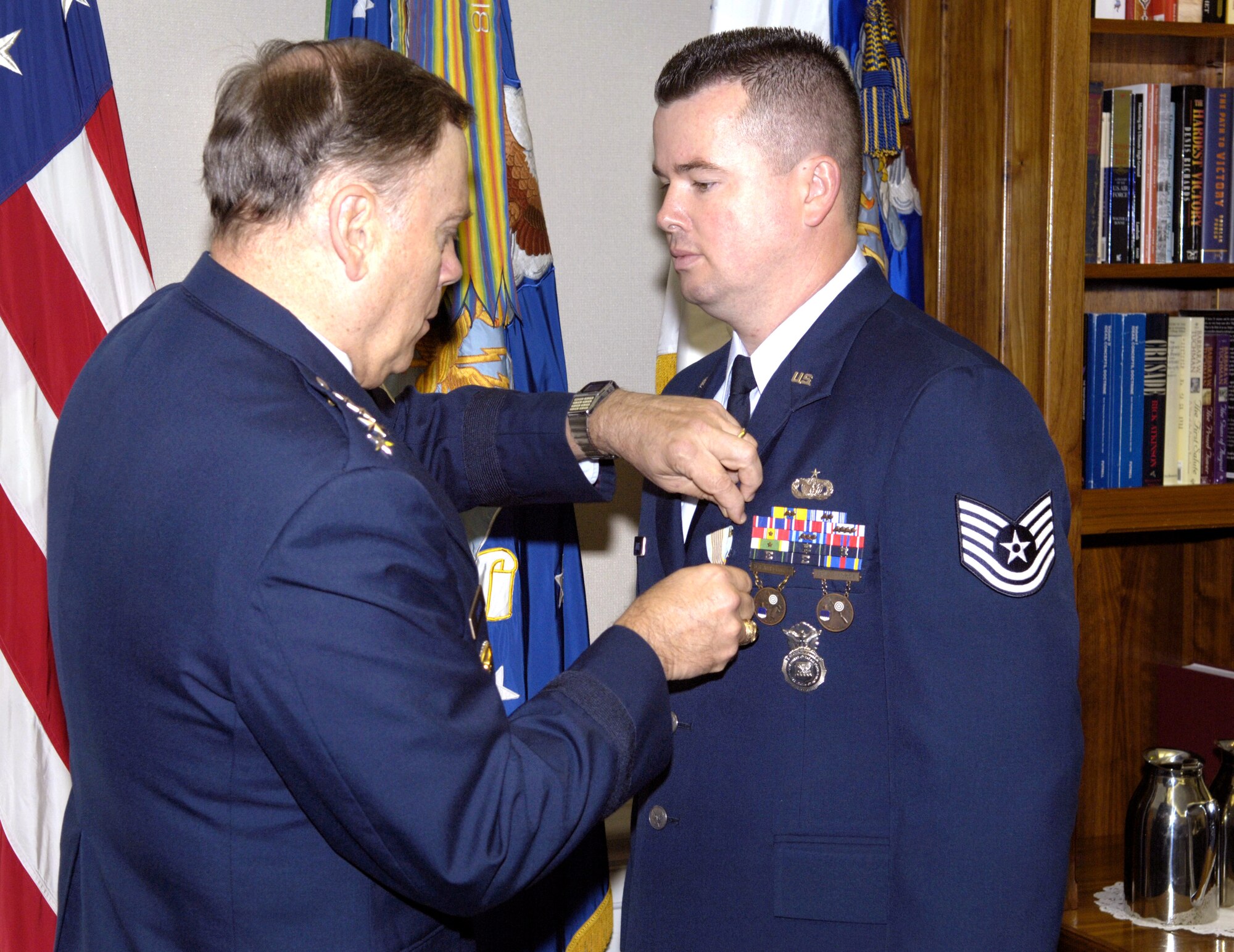WASHINGTON -- Air Force Chief of Staff Gen. John P. Jumper presents an Airman's Medal to Tech. Sgt. Michael Downey II during a ceremony here Aug. 31.  Sergeant Downey was awarded the medal for displaying exemplary courage and heroism on Oct. 17, 2003, when he swam to a vehicle that had just crashed into a canal, freed the 89-year-old driver who was trapped inside the vehicle and swam her to safety.  (U.S. Air Force photo by Master Sgt. Jim Varhegyi)