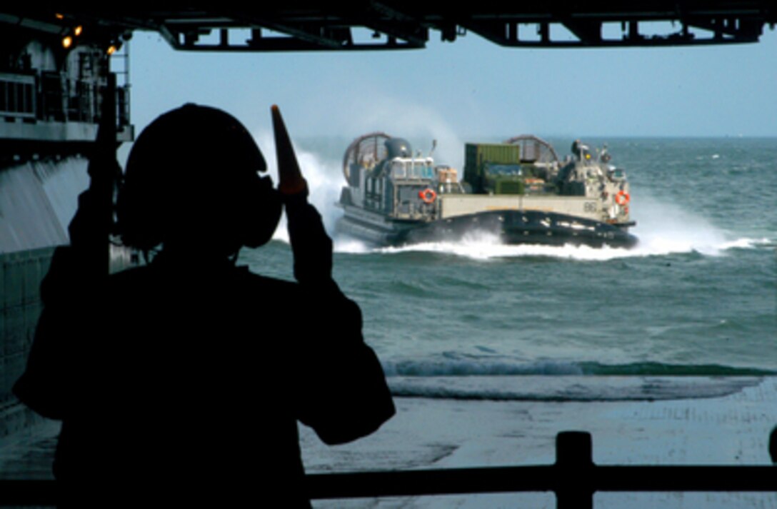 Navy Seaman Whitney Clark directs a Landing Craft Air Cushion into the well deck of the USS Iwo Jima (LHD 7) as it steams toward the Gulf Coast on Aug. 31, 2005. The multi-purpose, amphibious assault ship will join other military assets as part of Joint Task Force Katrina. Joint Task Force Katrina will support the Federal Emergency Management Agency's disaster-relief efforts in the Gulf Coast areas devastated by Hurricane Katrina. The Landing Craft Air Cushion, more commonly known as an LCAC, can be used to deliver personnel, supplies and equipment to the beach. 