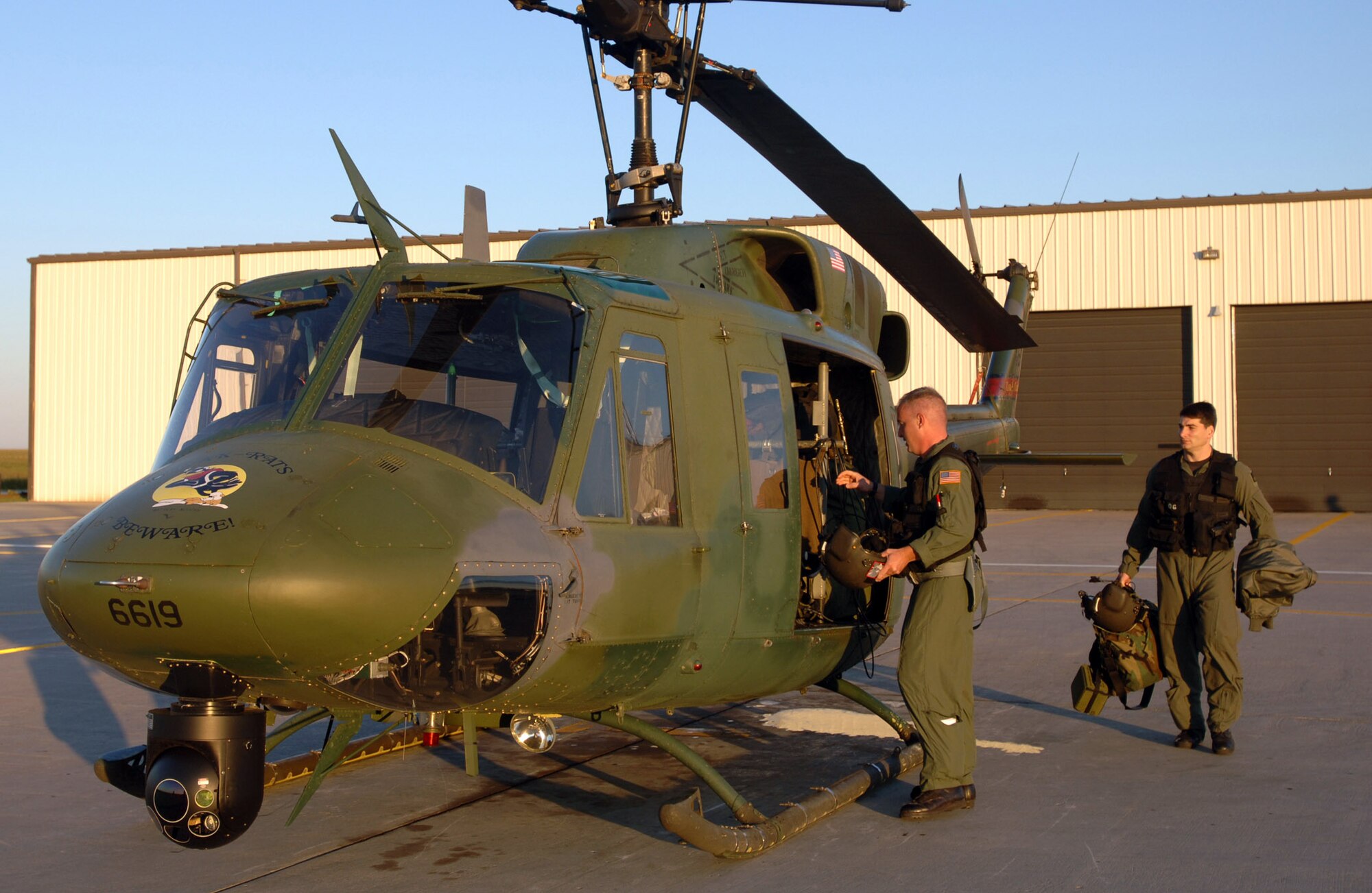 MINOT AIR FORCE BASE, N.D. --- Tech. Sgt. James Heath (left) and Maj. Brian McGraw finish loading a UH-1N Huey in preparation for takeoff here Sept. 2.  The crew departed for Columbus Air Force Base, Miss., to assist in the Hurricane Katrina disaster relief efforts.  Thirteen people and a helicopter from the 54th Helicopter Flight are deploying to aid the recovery.  (U.S. Air Force photo by Staff Sgt. Joe Laws) 