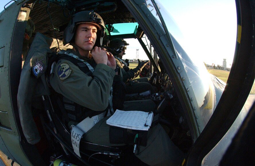 MINOT AIR FORCE BASE, N.D. --- Capt. David Fink adjusts his helmet strap in a UH-1N Huey helicopter in preparation for takeoff here Sept. 2.  Captain Fink and a crew departed for Columbus Air Force Base, Miss., to assist in the Hurricane Katrina disaster relief efforts.  Thirteen people and a helicopter from the 54th Helicopter Flight are deploying to aid the recovery.  (U.S. Air Force photo by Staff Sgt. Joe Laws)