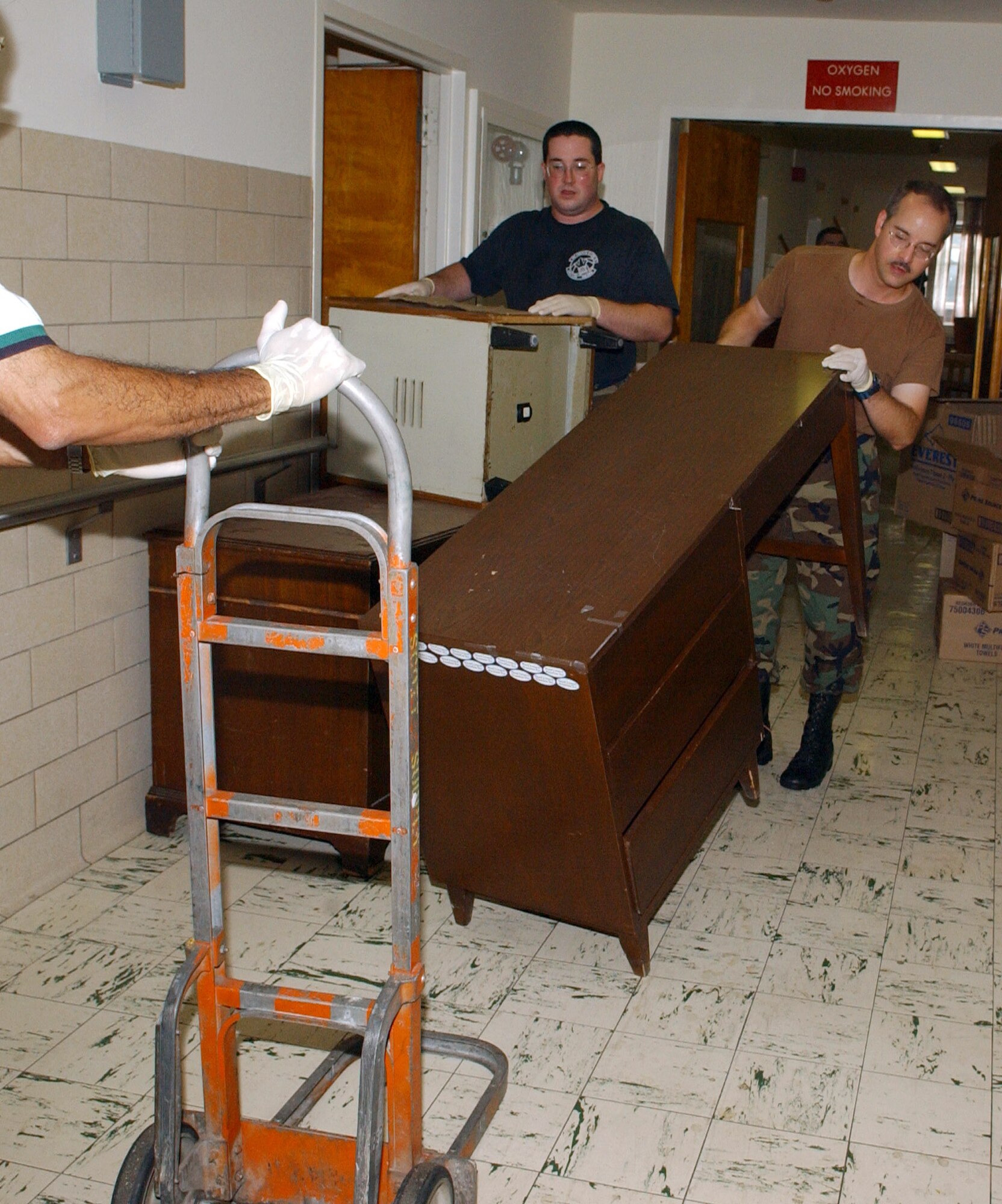 WASHINGTON -- Tech. Sgt. Chris Longoria (left) and Master Sgt. Philip Krzywicki move furniture along with more than 100 volunteers from Bolling Air Force Base, D.C., on Aug. 31 to clean and set up 125 rooms at the Armed Forces Retirement Home here in preparation for the arrival of veterans displaced by the effects of Hurricane Katrina.  More than 400 veterans from Gulfport, Miss., are being housed at the retirement home until their facility can be repaired, which is estimated to take more than a year.  Sergeant Longoria is assigned to the Air Force media services headquarters and Sergeant Krzywicki is part of the U.S. Air Force Band.  (U.S. Air Force photo by Staff Sgt. Amber K. Whittington) 