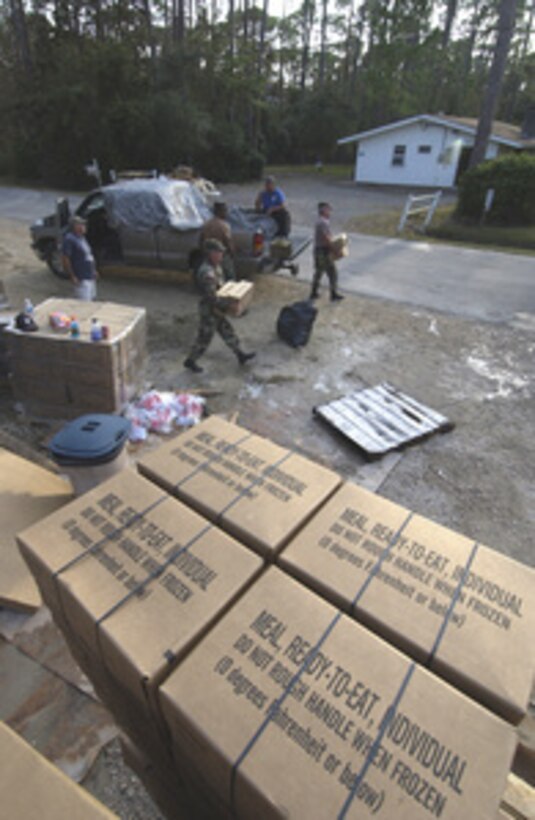 U.S. Army National Guard Sgt. Burl Gulledge and Sgt. 1st Class James F. McLerd grab boxes of Meals, Ready-To-Eat that will be given to residents of Dauphin Island, Ala., on Sept. 1, 2005. Department of Defense units are mobilized as part of Joint Task Force Katrina to support the Federal Emergency Management Agency's disaster-relief efforts in the Gulf Coast areas devastated by Hurricane Katrina. Gulledge and McLerd are assigned to the Army National Guard's 900th Maintenance Company, Brundidge, Ala. 