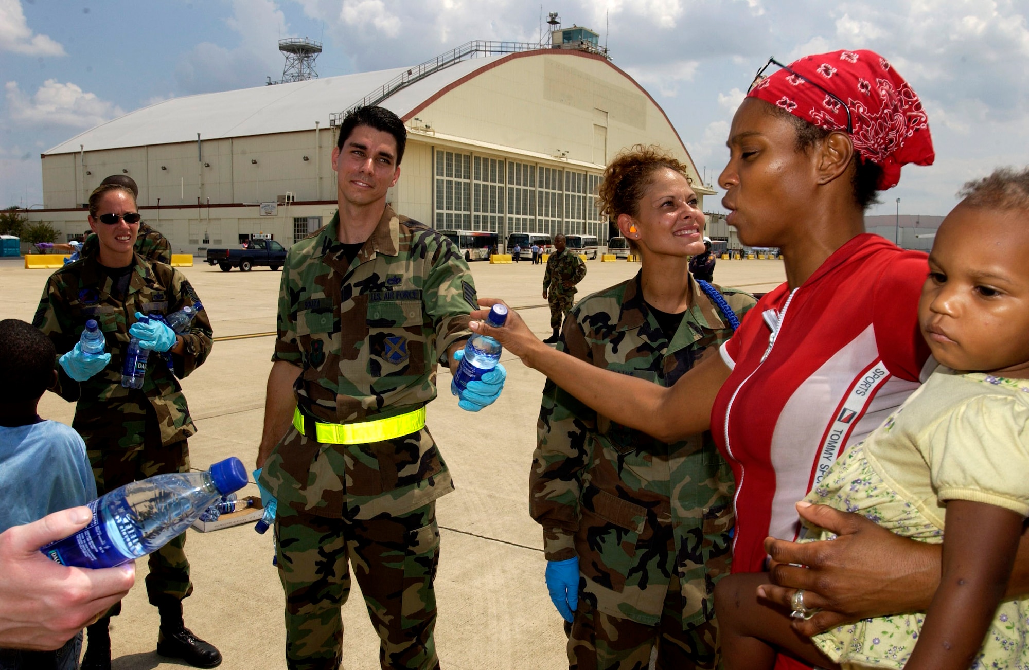 LACKLAND AIR FORCE BASE, Texas -- Staff Sgt. John Souza hands out water to Hurricane Katrina evacuees here. The evacuees arrived Sept. 2 from New Orleans. They are being inprocessed, given a medical checkup, fed and put into temporary shelters.  Sergeant Souza is assigned to the 343rd Training Squadron.  (U.S. Air Force photo by Tech. Sgt. Mark Borosch)