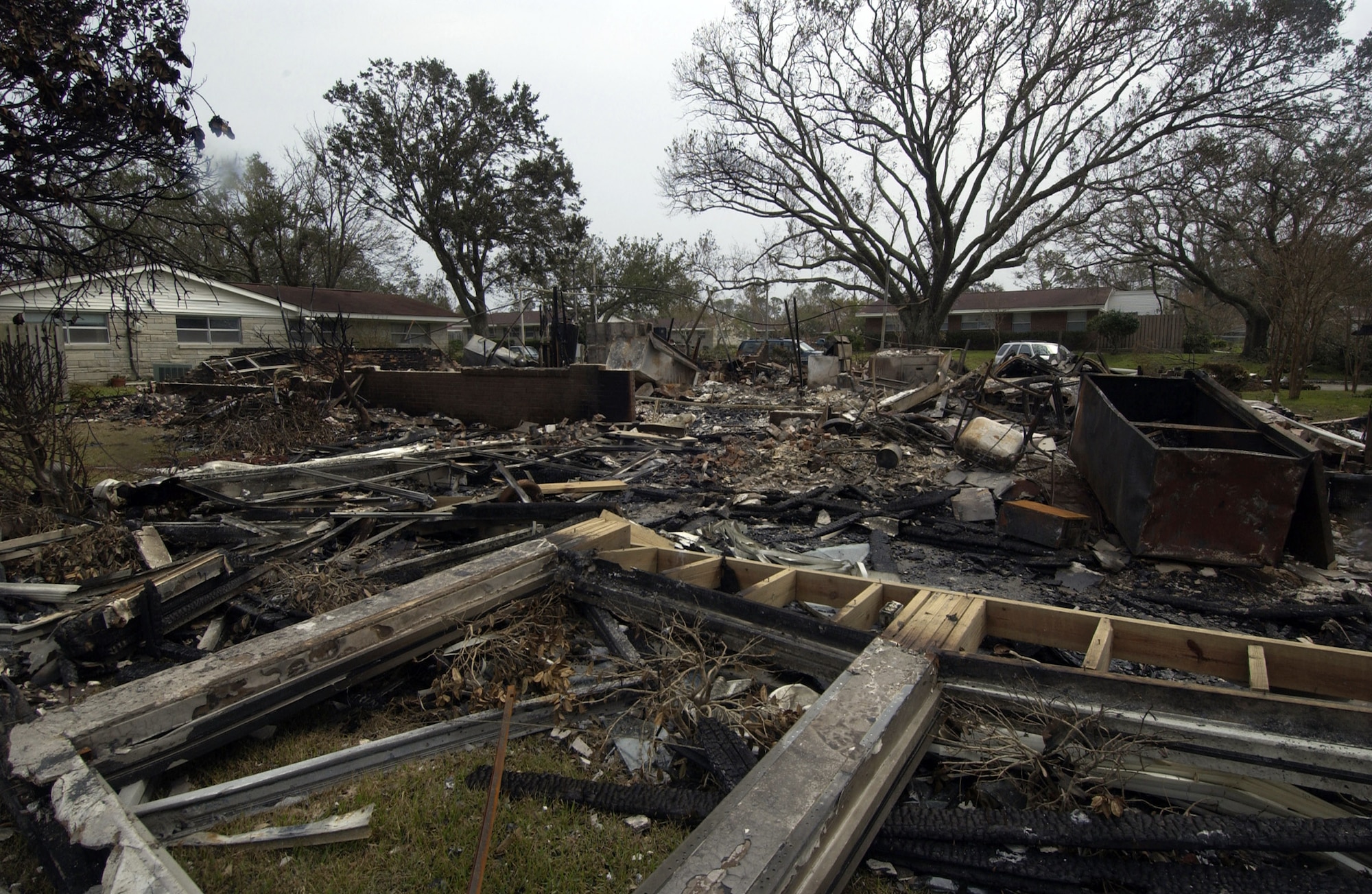 KEESLER AIR FORCE BASE, Miss. -- Fire department officials examine the charred rubble of the home belonging to Col. Bruce Bush, 81st Mission Support Group commander, Sept. 1. The house exploded during Hurricane Katrina, a Category 4 storm that roared through the base three days earlier. Katrina battered the Gulf Coast with wind gusts in excess of 140 mph, flattening buildings and flooding areas from Florida to Louisiana. Millions of people are left without power, and hundreds of thousands are homeless. (U.S. Air Force photo by Tech. Sgt. Jennifer C. Wallis) 