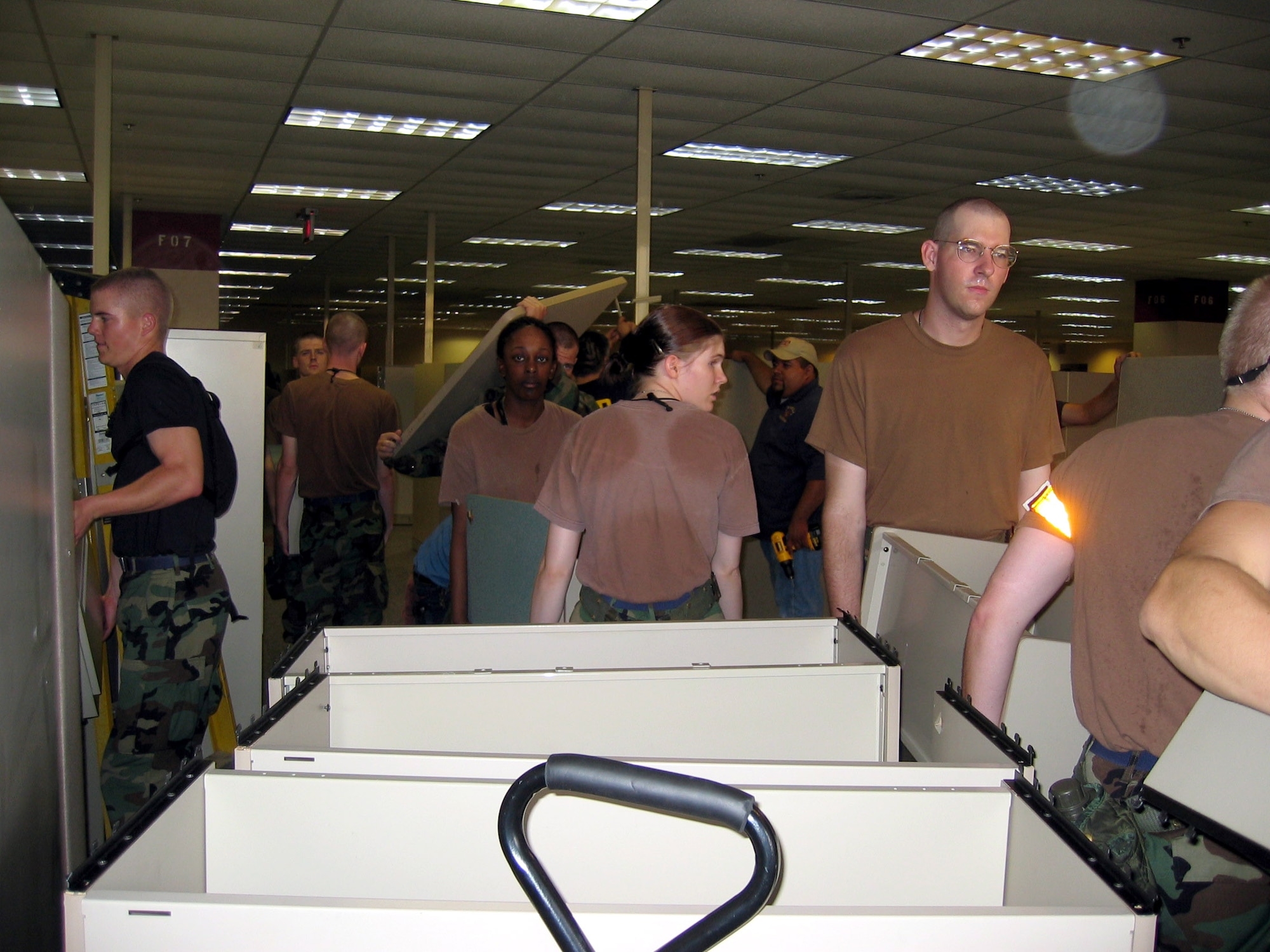 SAN ANTONIO -- Airmen from nearby Lackland Air Force Base remove modular office furniture to make room for people displaced by Hurricane Katrina. In all, 200 Airmen helped turn a 350,000 square foot office building into a living area.  (U.S. Air Force photo by Tech. Sgt. J.C. Woodring)