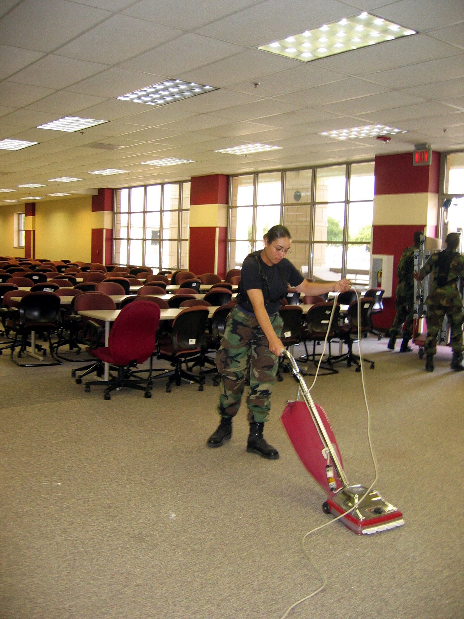 SAN ANTONIO -- Airman Ebony Jenkins puts the final touches on the dining area for people displaced by Hurricane Katrina. In all, 200 Airmen from nearby Lackland Air Force Base helped tear down modular office furniture in a 350,000 square foot building and set up the cots. Airman Jenkins is assigned to the 320th Training Squadron.  (U.S. Air Force photo by Tech. Sgt. J.C. Woodring)