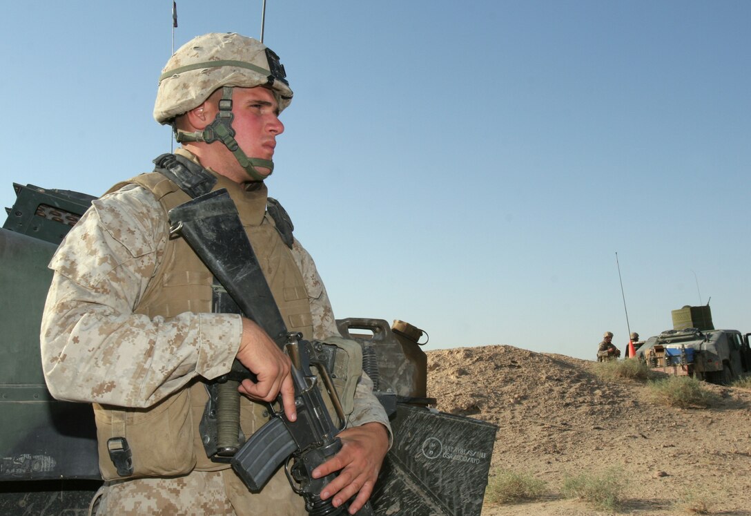 Lance Cpl. Jamby Perez, motor transport operator, Headquarters Platoon, Bravo Company, 2nd Tank Battalion, 2nd Marine Division scans the Iraqi desert while standing duty on an observation point Sept. 3.  Perez decided to join the Marine Corps to make a difference.