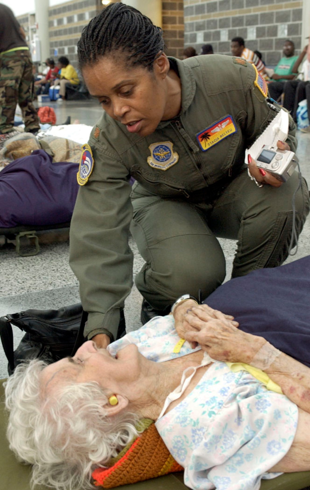 NEW ORLEANS -- Maj. Stacia Blyeu comforts an elderly patient at the Louis Armstrong New Orleans International Airport moments before she is evacuated from here Sept. 3.  Major Blyeu is a flight nurse with the 452nd Air Evacuation Squadron at March Air Reserve Base, Calif.  (U.S. Air Force photo by Master Sgt Jack Braden)