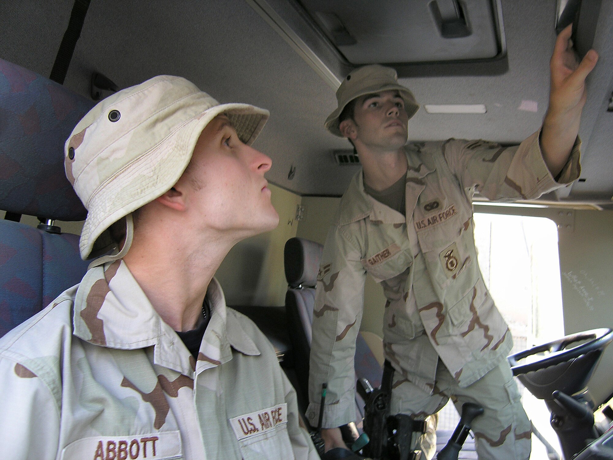 ALI BASE, Iraq -- Airman 1st Class Adam Gaither (right) shows volunteer Senior Airman Ben Abbott how to search a truck at the visitor control center here to make sure it is free of explosives or contraband items.  Airman Gaither is assigned to the 407th Expeditionary Security Forces Squadron, and Airman Abbott is assigned to the 407th Expeditionary Communications Squadron.  (U.S. Air Force photo by Tech. Sgt. Melissa Phillips)

  