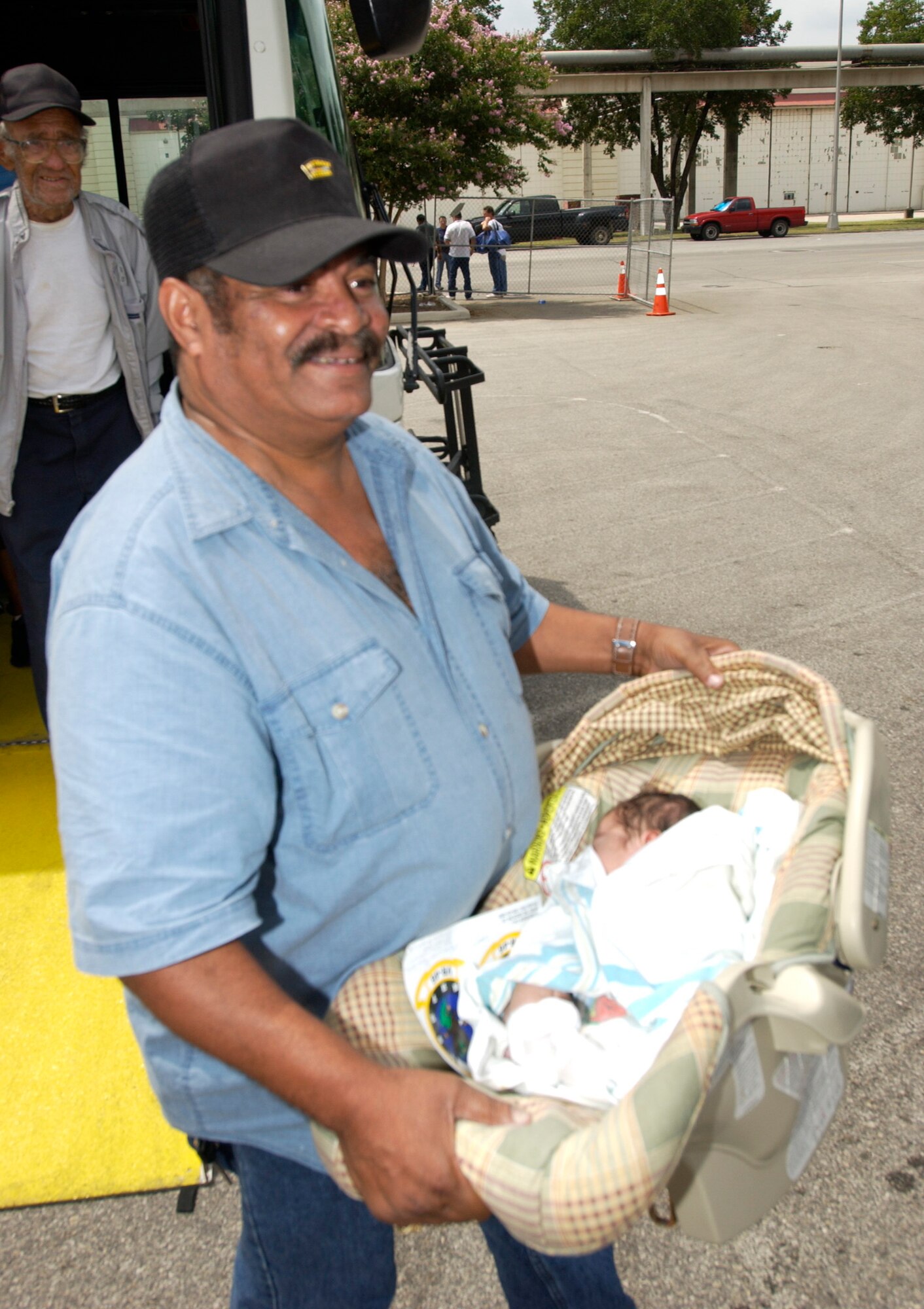 LACKLAND AIR FORCE BASE, Texas -- Ralf Price Sr. and his 6-day-old son, Jerry, arrive here from New Orleans on Sept. 3. The Hurricane Katrina evacuees are being inprocessed, given a medical checkup, fed and put into temporary shelters.  (U.S. Air Force photo by Tech. Sgt. Mark Borosch)