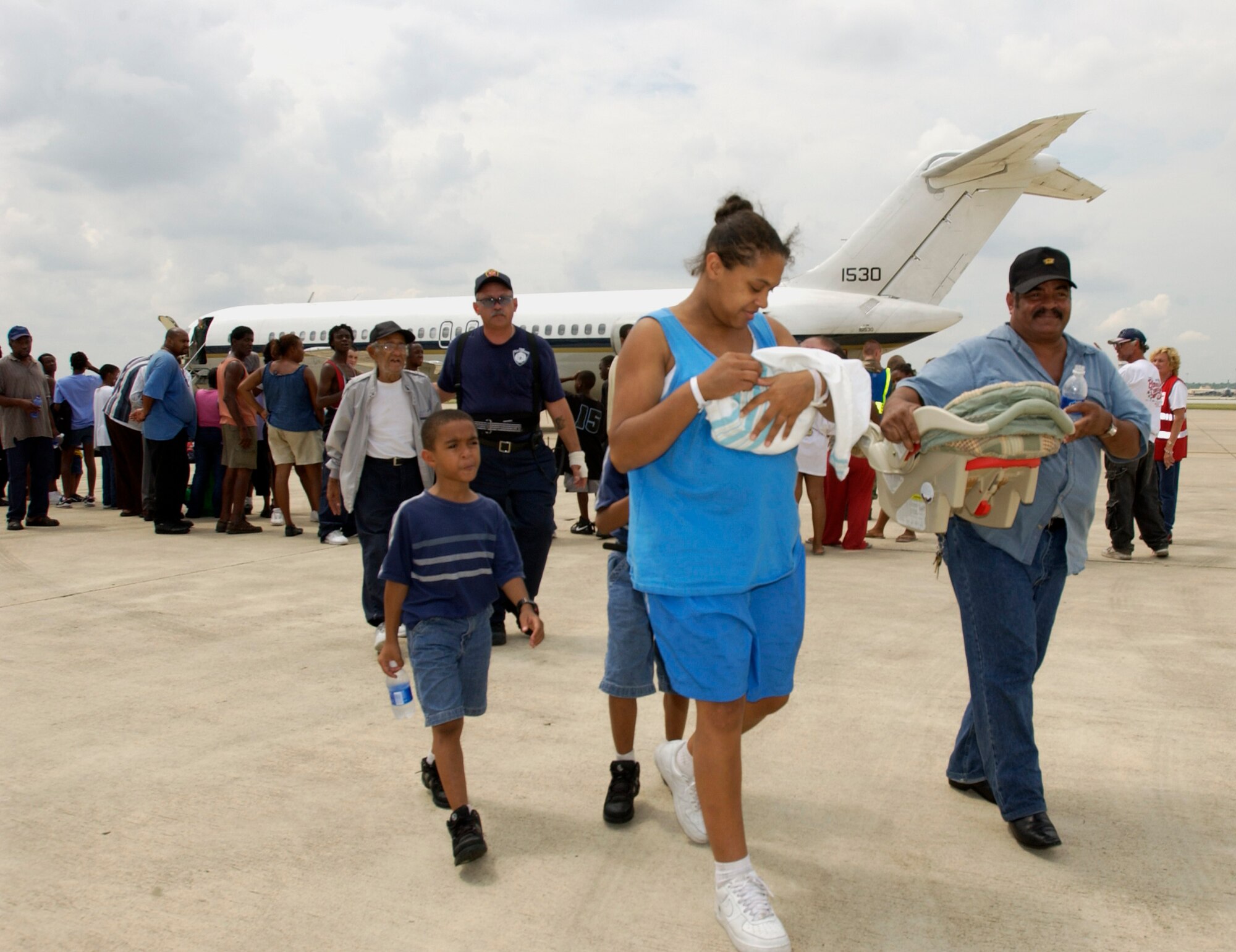 LACKLAND AIR FORCE BASE, Texas -- (From left) Ralf Price Jr., Dianna Price and Ralf Price arrive here with their family.  The Hurricane Katrina evacuees arrived Sept. 3 from New Orleans.  Evacuees are being inprocessed, given a medical checkup, fed and put into temporary shelters.  (U.S. Air Force photo by Tech. Sgt. Mark Borosch)