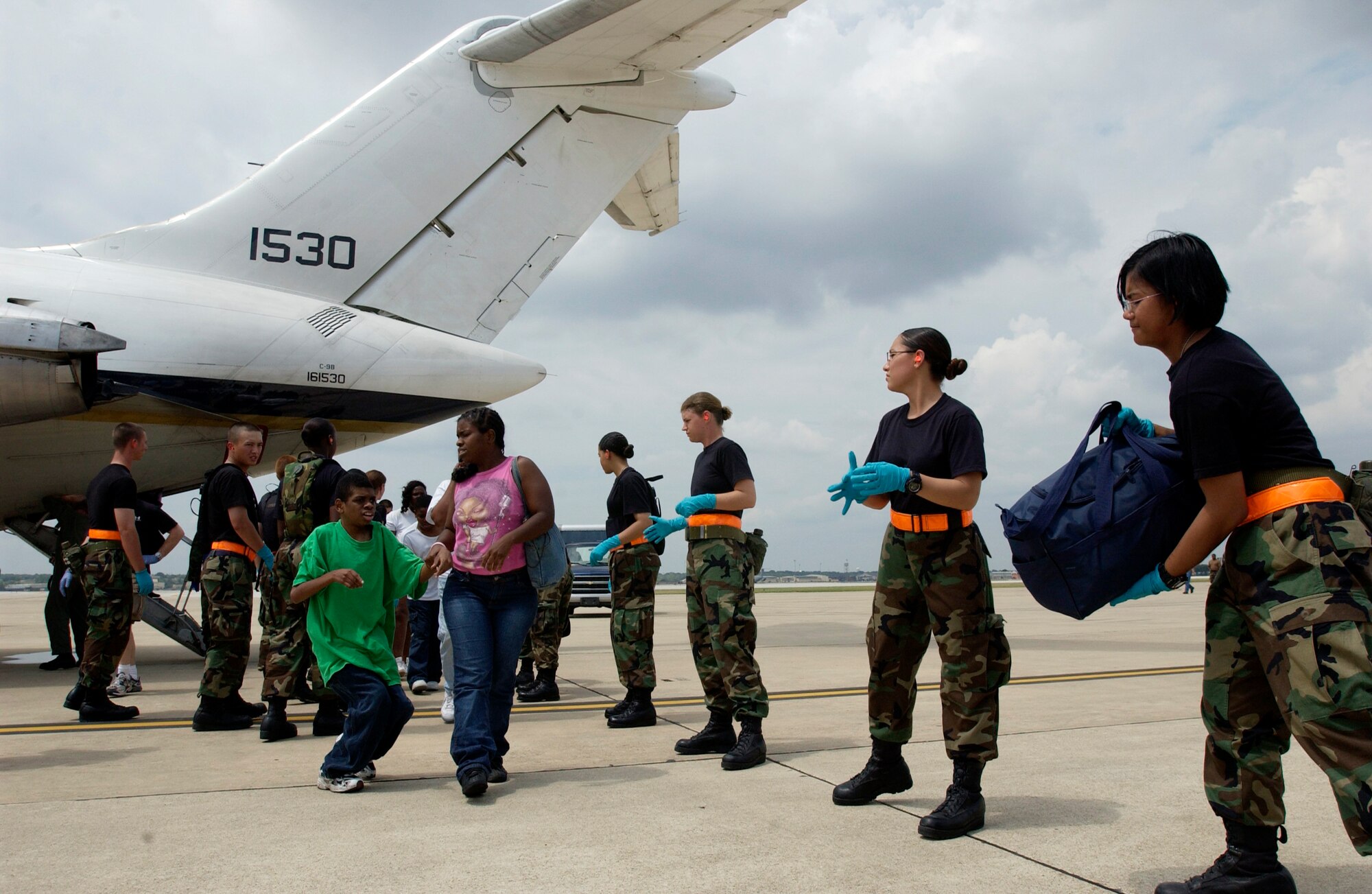 LACKLAND AIR FORCE BASE, Texas -- Airmen with the 320th Training Squadron here help unload luggage from a C-9 Nightingale aircraft that brought Hurricane Katrina evacuees from New Orleans on Sept. 3. Evacuees are being inprocessed, given a medical checkup, fed and put into temporary shelters.  (U.S. Air Force photo by Tech. Sgt. Mark Borosch)