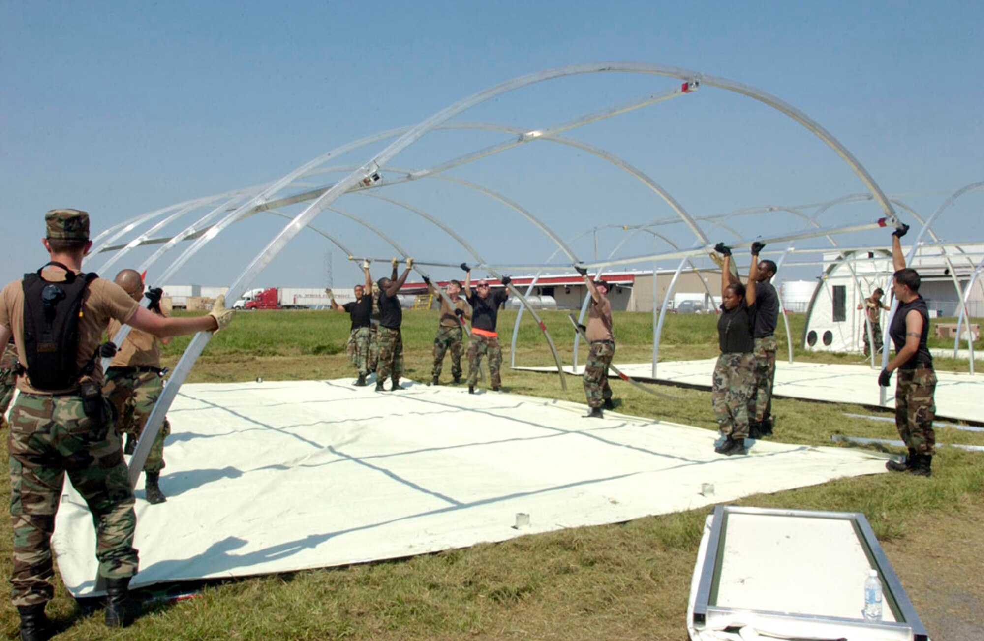 NEW ORLEANS -- Airman erect tents at Louis Armstrong International Airport here Sept. 4.  The tents were flown in from the 49th Materiel Maintenance Group at Holloman Air Force Base, N.M., to house workers supporting the Hurricane Katrina relief effort.  (U.S. Air Force photo by Master Sgt. Jack Braden)