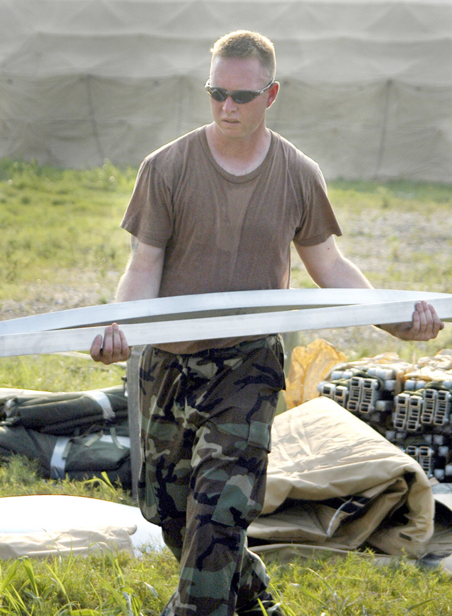 NEW ORLEANS -- Staff Sgt. Robbie Dunn hauls shelter frame pieces Sept. 3 at Louis Armstrong International Airport here.  He is part of a unit deployed to the airport to begin construction on a massive tent city that will house Airmen attending to Hurricane Katrina victims.  Sergeant Dunn is a 49th Materiel Maintenance Group utility technician from Holloman Air Force Base, N.M.   (U.S. Air Force photo by Airman 1st Class Stephen Collier)