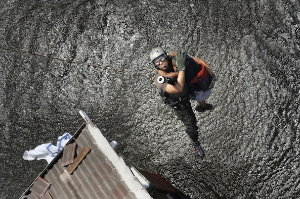 NEW ORLEANS -- Tech. Sgt. Lem Torres and a young boy are lifted to safety from the roof of the child's flooded home. The pararescueman is from 38th Rescue Squadron at Moody Air Force Base, Ga., and is deployed to New Orleans for Hurricane Katrina search-and-rescue operations. (U.S. Air Force photo by Staff Sgt. Manuel J. Martinez)
