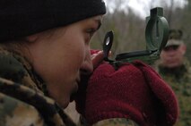 Katherine Hass, a 21-year-old officer candidate from the University of Wisconsin in Madison, Wis., finds her azimuth during the land navigation course at Fort McCoy, Wis., April 12, while a staff member supervises.  Hass was one of nearly 200 candidates to take part in the 9th Marine Corps District's Officer Candidate School preparatory weekend, where they were given a taste of OCS training. The candidates experienced the yelling of platoon sergeants, running a physical fitness test in harsh conditions, and finding their way through a land navigation course.