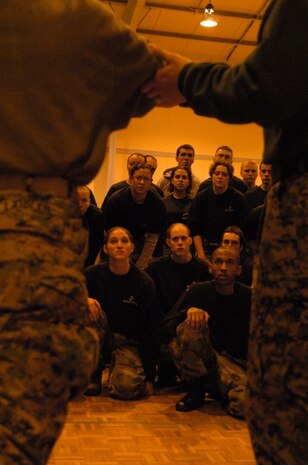 Officer candidates watch a platoon sergeant perform basic Marine Corps Martial Arts Program movements with a candidate at Fort McCoy, Wis., April 12. Nearly 200 candidates participated in the 9th Marine Corps District's Officer Candidate School preparatory weekend, which gave them a taste of OCS training. The candidates experienced the yelling of four platoon sergeants, running a physical fitness test in harsh conditions and finding their way through a land navigation course.