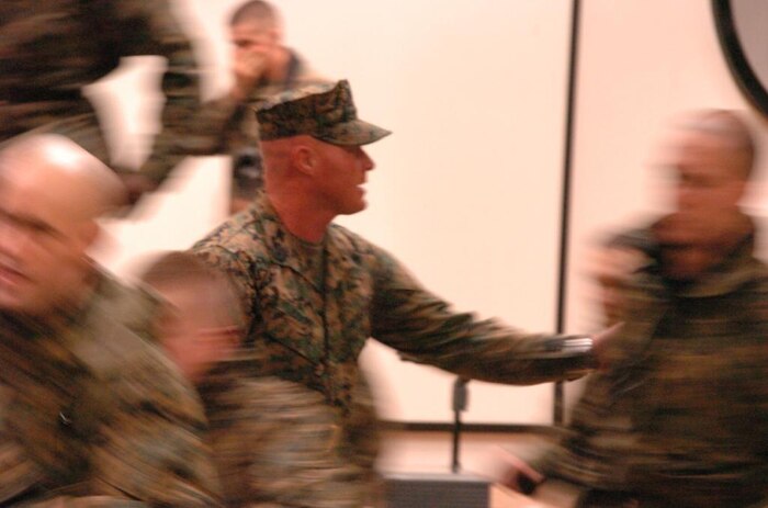 Gunnery Sgt. Max Coons, an Officer Candidate School platoon sergeant, rushes his platoon out of a building at the 9th Marine Corps District's OCS Preparatory Weekend April 11 at Fort McCoy, Wis. Coons was one of four platoon sergeants to help bring a taste of OCS to nearly 200 candidates. The preview let candidates experience the yelling of platoon sergeants, running a physical fitness test in harsh conditions and finding their way through a land navigation course.