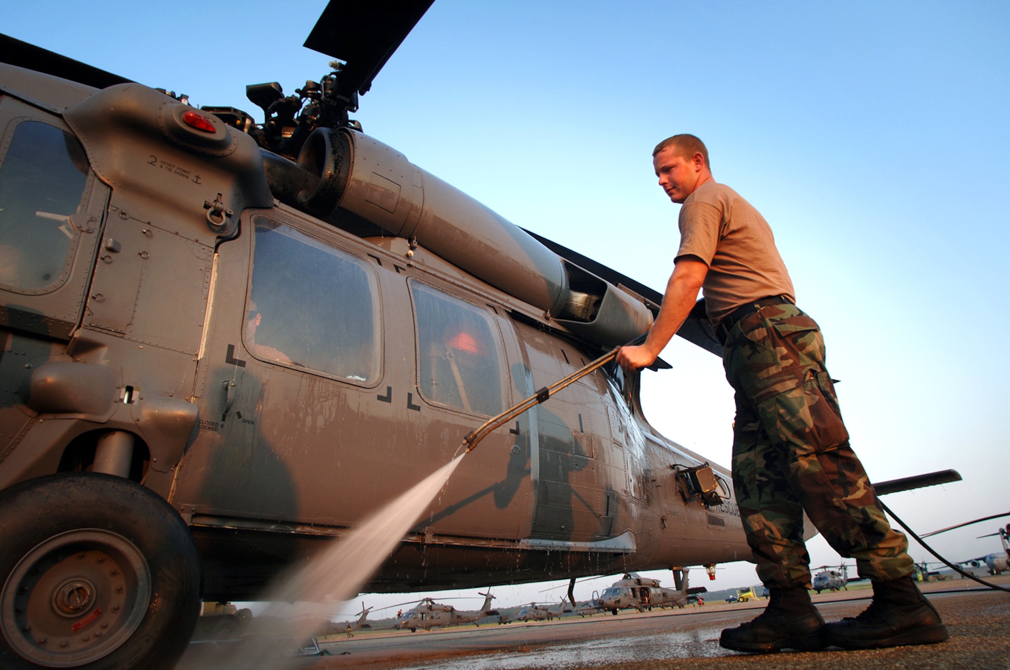JACKSON, Miss. -- Staff Sgt. Jason Moore uses a pressure washer to hose off an HH-60G Pave Hawk after a search and rescue mission.  Ground crews here wash the outside of helicopters with hot water and the inside with a mild bleach solution to decontaminate them after missions over "the soup."  That is the name used for Hurricane Katrina floodwaters polluted with fuel oil, diesel fuel and gasoline, raw sewage, the bodies of people and animals and hazardous chemicals.  Sergeant Moore is a 347th Expeditionary Rescue Group crew chief.  (U.S. Air Force photo by Master Sgt. Efrain Gonzalez)