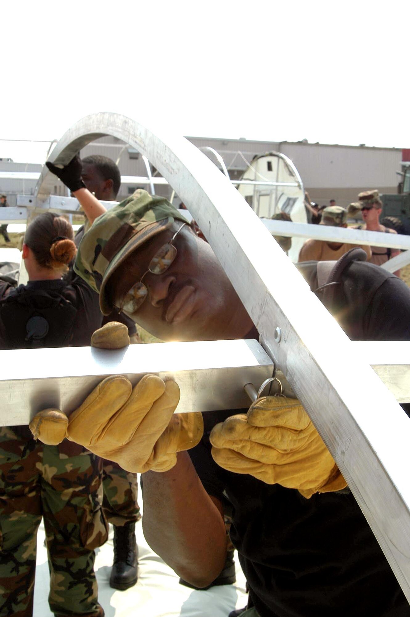 LOUIS ARMSTRONG NEW ORLEANS INTERNATIONAL AIRPORT, La. -- Master Sgt. Rod Harris secures a pin in an Alaskan shelter here Sept. 5.  More than 30 shelters have been built up to support additional Airmen coming here to help support the Hurricane Katrina relief and rebuilding efforts in New Orleans.  Sergeant Harris is the loading superintendent of the 55th Services Squadron from Offutt Air Force Base, Neb.  (U.S. Air Force photo by Airman 1st Class Stephen Collier)

