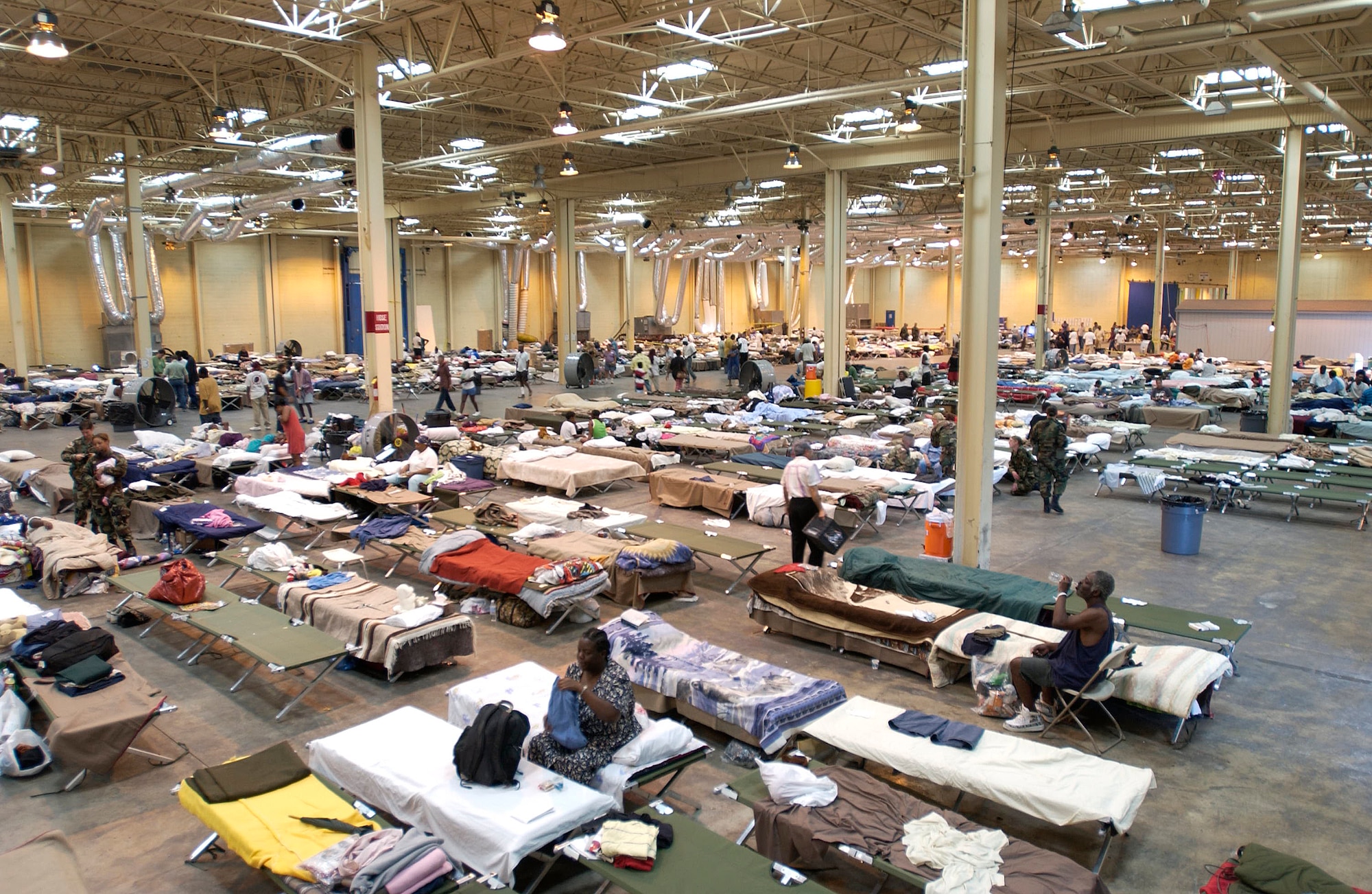 SAN ANTONIO - Gulf Coast evacuees relax on cots set up inside warehouses here converted to temporary shelters.  They were inprocessed, given a medical checkup, fed and provided donated clothing and other personal needs.  (U.S. Air Force photo by Tech. Sgt. Mark Borosch)