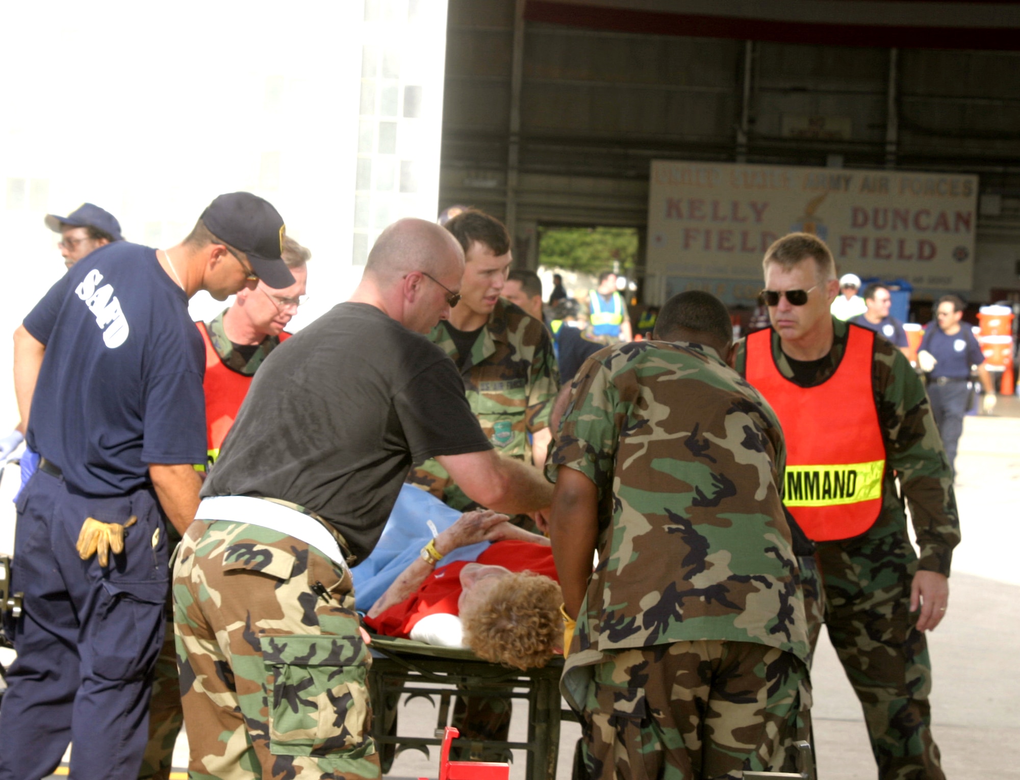 LACKLAND AIR FORCE BASE, Texas -- Emergency responders tend to injured evacuees Sept. 3.  C-130 Hercules crews from the 50th Airlift Squadron at Little Rock Air Force Base, Ark., teamed up with Airmen from the 452nd Aeromedical Evacuation Squadron at March Air Reserve Base, Calif., to relocate sick and injured patients devastated after Hurricane Katrina.  (U.S. Air Force photo by 1st Lt. Jon Quinlan)