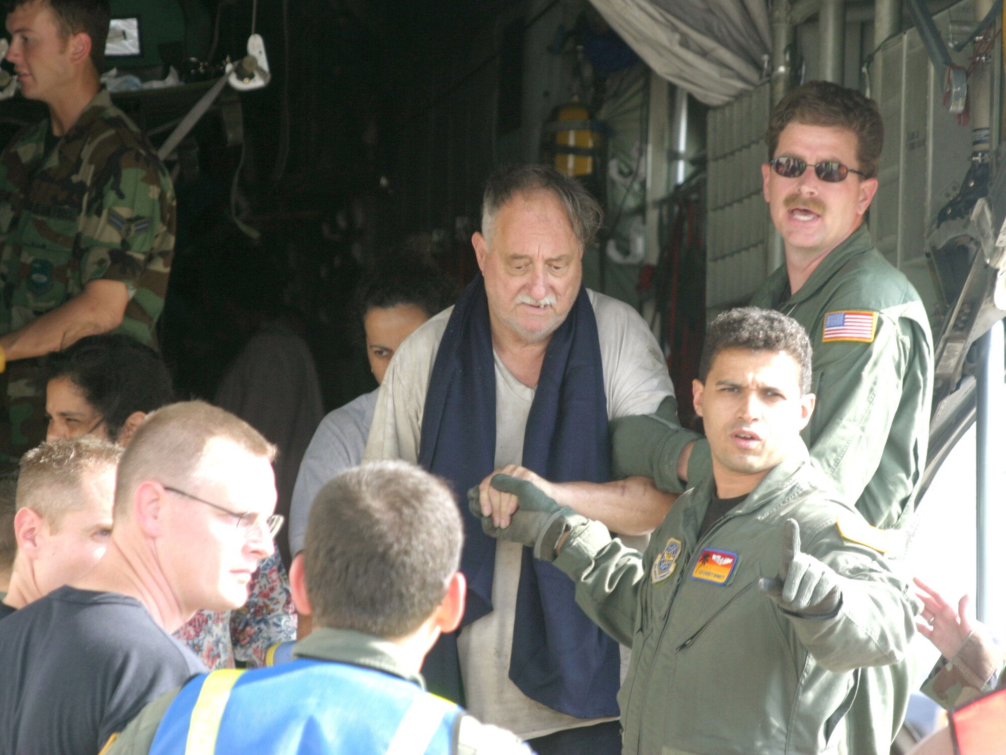 LACKLAND AIR FORCE BASE, Texas -- Airmen with the 452nd Aeromedical Evacuation Squadron from March Air Reserve Base, Calif., escort evacuees from a C-130 Hercules on Sept. 3.  C-130 crews from the 50th Airlift Squadron at Little Rock teamed up with the 452nd AES to relocate sick and injured patients devastated after Hurricane Katrina.  (U.S. Air Force photo by 1st Lt. Jon Quinlan)