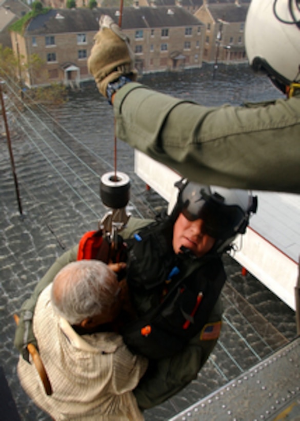 U.S. Navy Petty Officer 1st Class Tim Hawkins retrieves a survivor of Hurricane Katrina from a rooftop in New Orleans, La., on Sept. 5, 2005. Department of Defense units are mobilized as part of Joint Task Force Katrina to support the Federal Emergency Management Agency's disaster-relief efforts in the Gulf Coast areas devastated by Hurricane Katrina. 