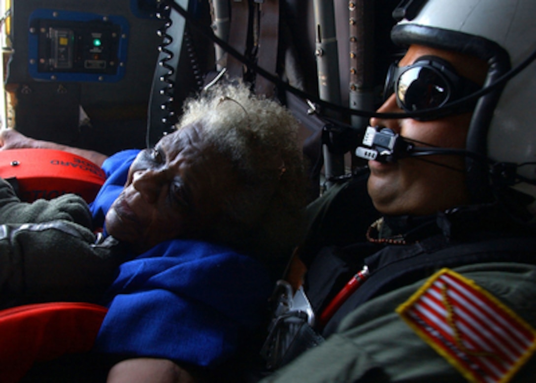 Navy Search and Rescue Swimmer Petty Officer 1st Class Scott Chun hangs on to an evacuee pulled from a rooftop in New Orleans, La., as his SH-60B Seahawk helicopter heads for the landing zone on Sept. 5, 2005. Department of Defense units are mobilized as part of Joint Task Force Katrina to support the Federal Emergency Management Agency's disaster-relief efforts in the Gulf Coast areas devastated by Hurricane Katrina. 