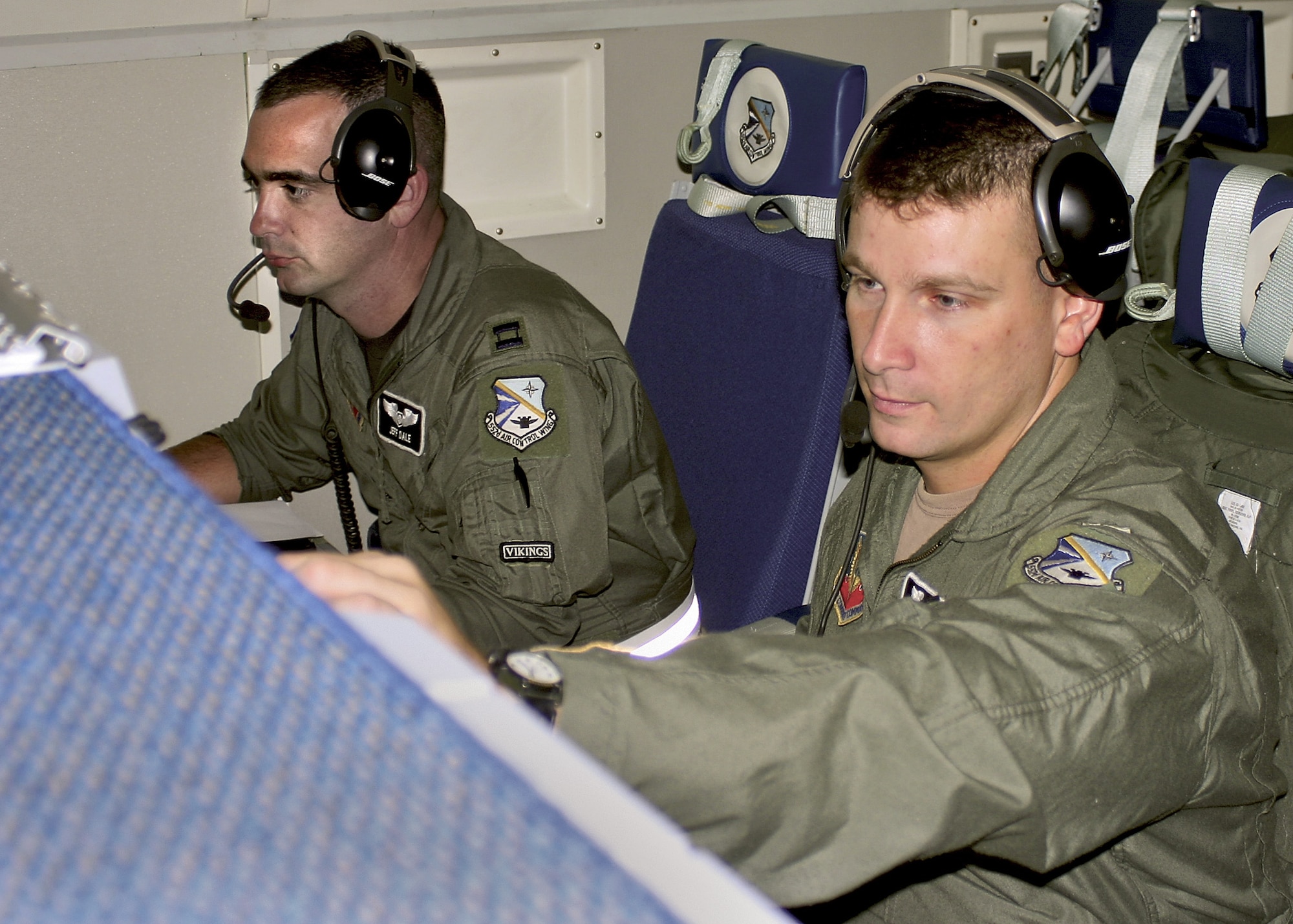 OVER LOUISIANA -- Capt. Jeff Dale (left) and 1st Lt. John Zanfardino track search-and-rescue aircraft here Sept. 7 in an E-3 Sentry airborne warning and control system aircraft.  The air weapons officers usually track fighter aircraft on their radars.  They are assigned to the 960th Airborne Air Control Squadron at Tinker Air Force Base, Okla.  (U.S. Air Force photo by Staff Sgt. Stacy L. Fowler)