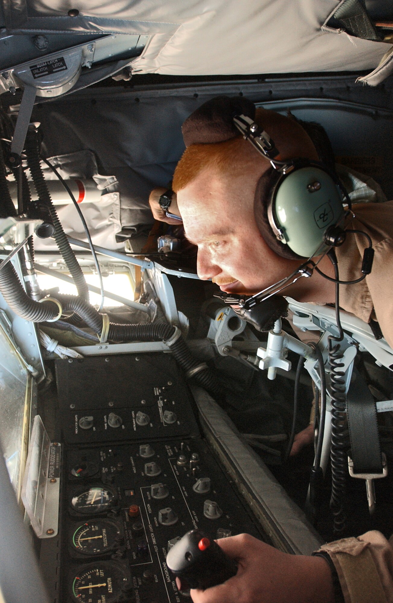 OVER IRAQ -- Airman 1st Class Philip Inmon moves the joystick as a fighter aircraft flies in close for fuel.  The boom operator uses the joystick to maneuver a boom that connects his KC-135 Stratotanker with another aircraft, and the transfer of fuel allows the other aircraft to stay airborne longer.  Airman Inmon is a KC-135 boom operator and is deployed from McConnell Air Force Base, Kan.  (U.S. Air Force photo by Staff Sgt. Justin Jacobs)