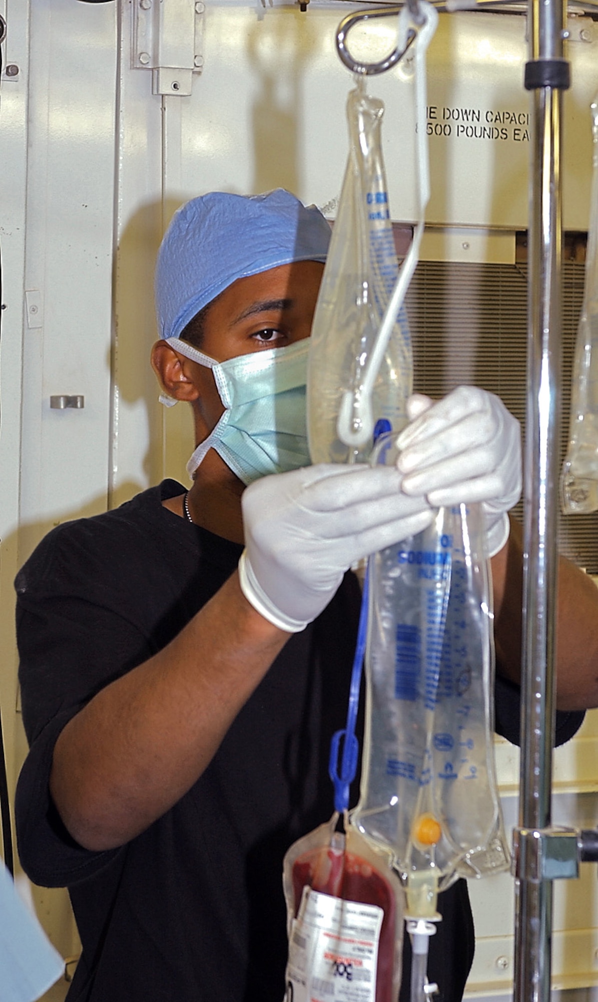 BAGHDAD, Iraq -- Staff Sgt. Charles Berry keeps blood and fluids flowing in the operating room as doctors treat a patient injured in an insurgent attack.  The doctors, nurses and other medics with the 447th Expeditionary Medical Squadron here have treated more than 3,000 patients during the past five months.  Sergeant Berry is deployed from Maxwell Air Force Base, Ala.  (U.S. Air Force photo by Tech. Sgt. Brian Davidson)