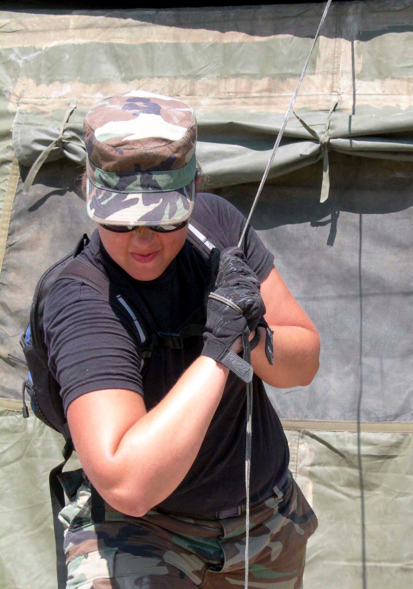 LOUIS ARMSTRONG NEW ORLEANS INTERNATIONAL AIRPORT, La. -- Airman 1st Class Alyson Baird tightens the stanchion for a tent Sept. 8.  She and other Airmen with the 4th Expeditionary Civil Engineer Squadron worked with Soldiers from the 82nd Airborne Division to build a tent city here for Soldiers supporting humanitarian efforts in New Orleans.  Airman Baird is deployed from McGuire Air Force Base, N.J.  (U.S. Air Force photo by Staff Sgt. Bryan Bouchard)