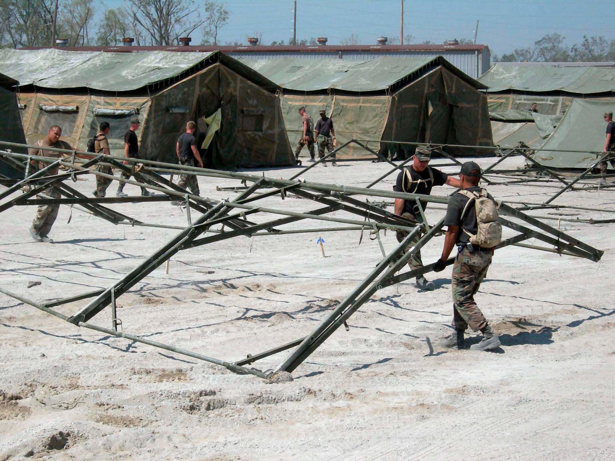 LOUIS ARMSTRONG NEW ORLEANS INTERNATIONAL AIRPORT, La. -- Airmen with the 4th Expeditionary Civil Engineer Squadron and Soldiers with the 82nd Airborne Division move a frame into place for a tent.  The two groups worked to build a tent city here for Soldiers supporting humanitarian efforts in New Orleans.  (U.S. Air Force photo by Staff Sgt. Bryan Bouchard)