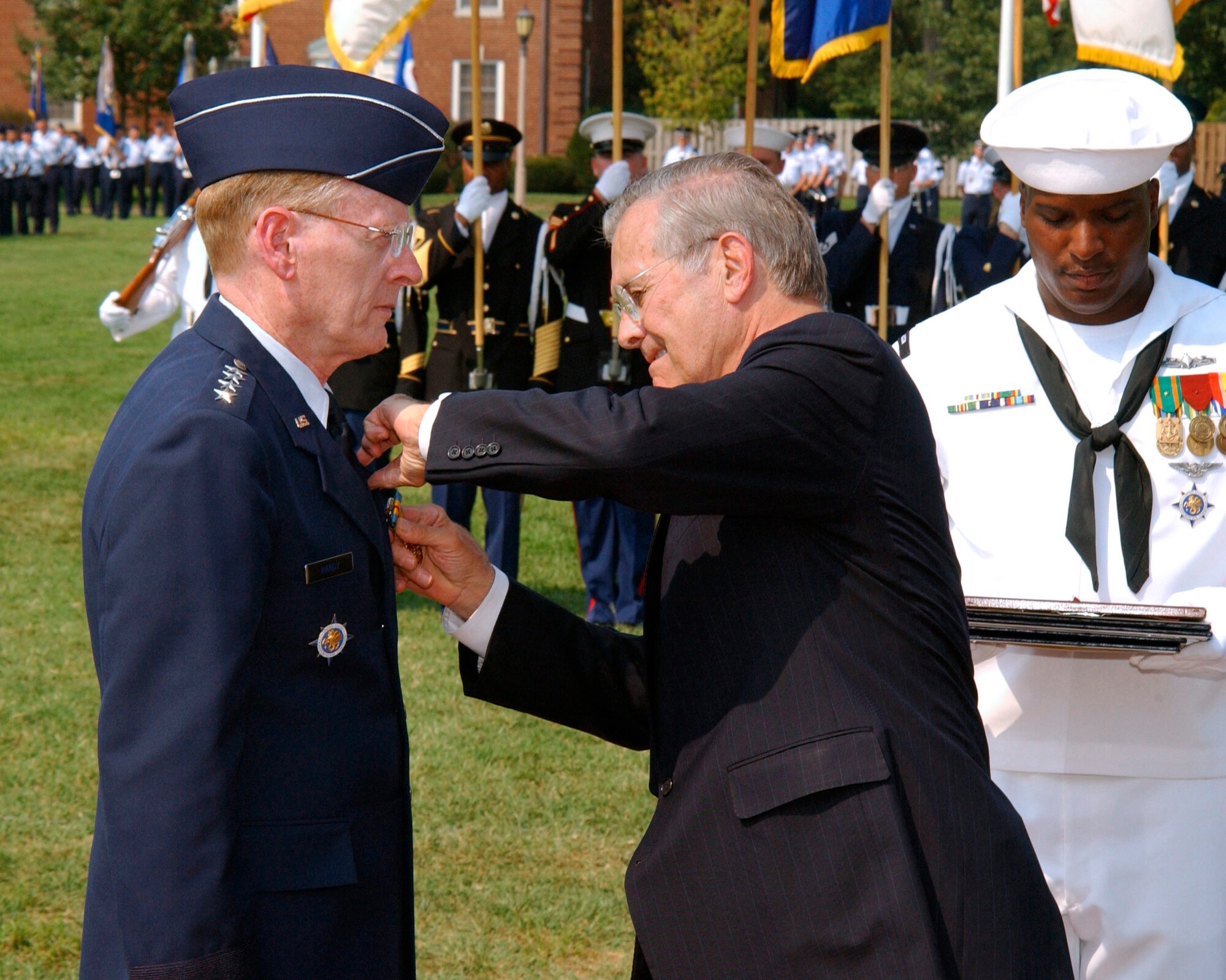 SCOTT AIR FORCE BASE, Ill -- Defense Secretary Donald H. Rumsfeld pins the Distinguished Service Medal on outgoing U.S. Transportation Command commander Gen. John W. Handy during the TRANSCOM change of command ceremony here Sept. 7.  Gen. Norton A. Schwartz assumed command.  (U.S. Air Force photo by Senior Airman David Clark)
