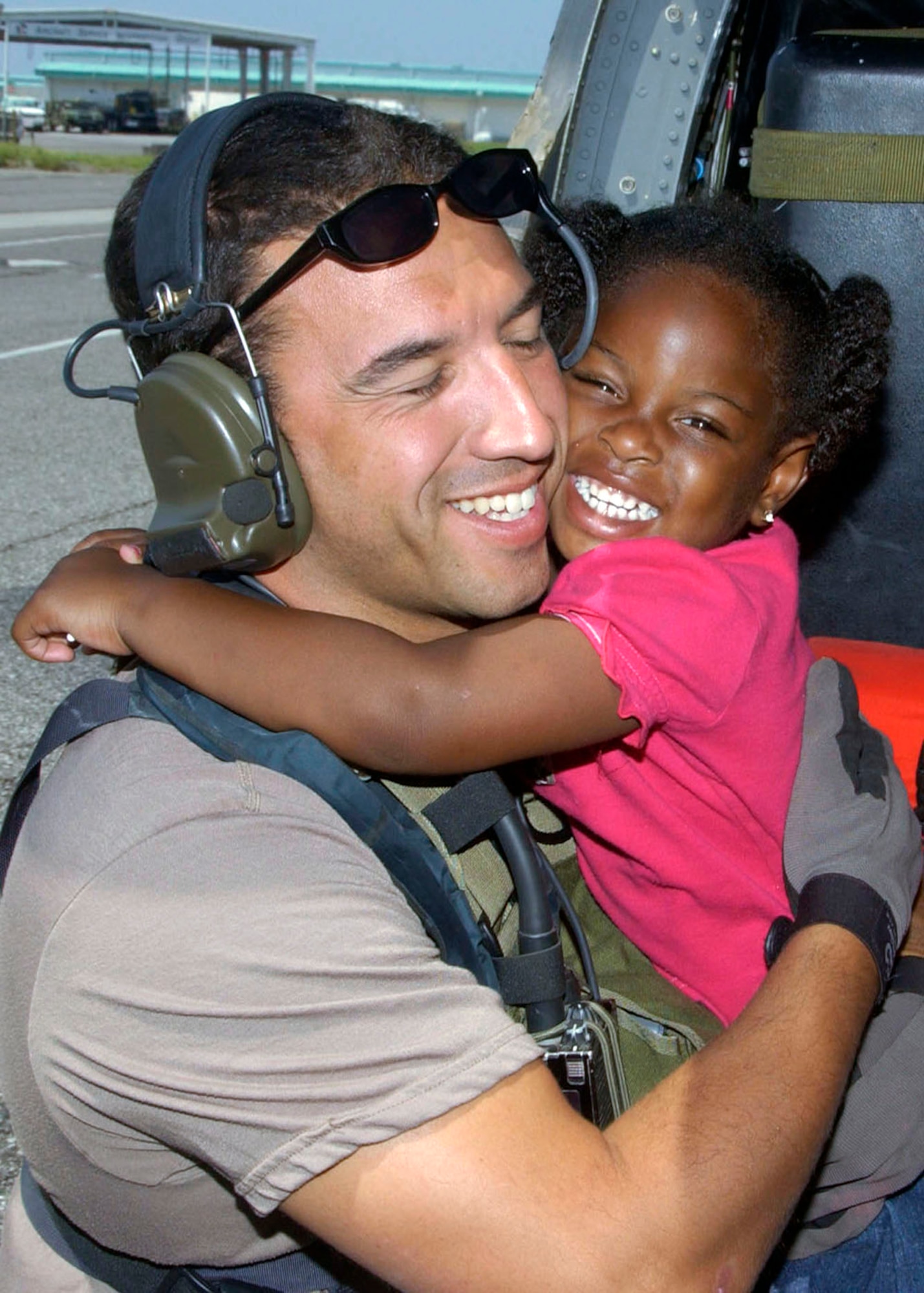 NEW ORLEANS -- A young Hurricane Katrina survivor hugs her rescuer, Staff Sgt. Mike Maroney, after she was relocated to the Louis Armstrong New Orleans International Airport, La., on Sept. 7.  Sergeant Maroney is a pararescueman from the 58th Rescue Squadron at Nellis Air Force Base, Nev.  (U.S. Air Force photo by Airman 1st Class Veronica Pierce)