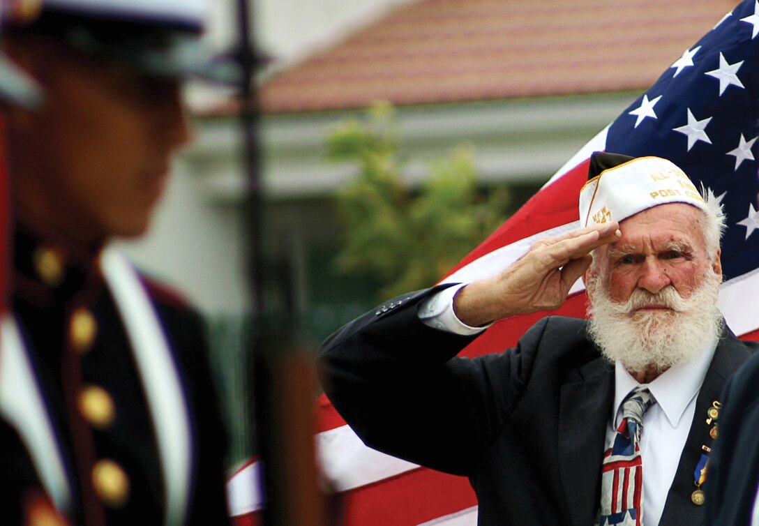 Military Veteran Alex Kapitanski holds a salute as a Marine color guard posts during a memorial ceremony at the South Mesa staff non-commissioned officer's club Sept. 2.  The memorial was in honor of the anniversary of the 4th Marine Divisions Deactivation.