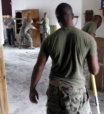 Marines from A Company, 1st Battalion, 8th Marines join Staff Sgt. Edward J. Schneider in moving furniture to access waterlogged sheetrock in order to remove it. Schneider, stationed in New Orleans, requested help from the battalion after his home was severely damaged by floodwaters from storm surge brought on by Hurricane Katrina.