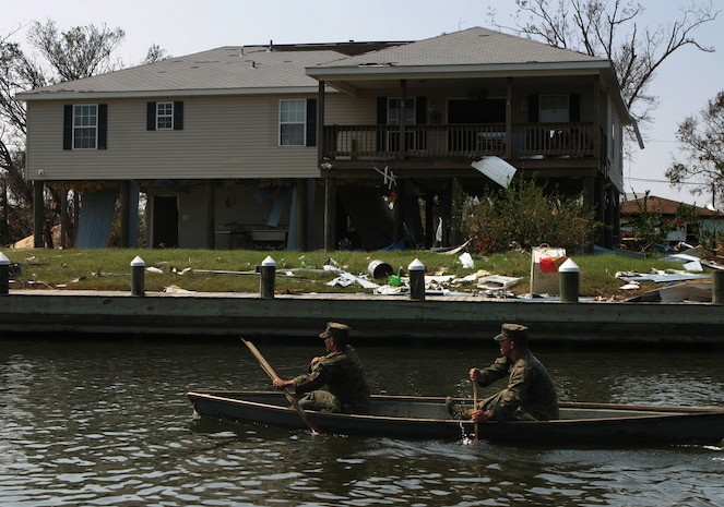 ST. BERNARD PARISH, La. (Sep. 10, 2005) -Using a 'Jim boat' pulled from a tree and make shift paddles, Cpl. Kyle E. Gaubert and Lance Cpl. Brandon K. Burleigh, riflemen with 1st Platoon, Bravo Company, 1/8, cross a small canal in order to search homes unreachable from any other way. The Marines of Bravo's 1st Platoon were the first on the ground to search the remote community in St. Bernard Parish.
