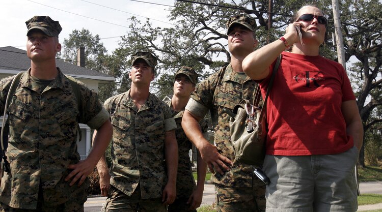 Marines from A Company, 1st Battalion, 8th Marines and Kathleen Faircloth survey the damage to Faircloth's roof September 10 in the aftermath of Hurricane Katrina. Faircloth is the mother of Lance Cpl. Bradley Faircloth, killed in action Nov. 26, 2004.