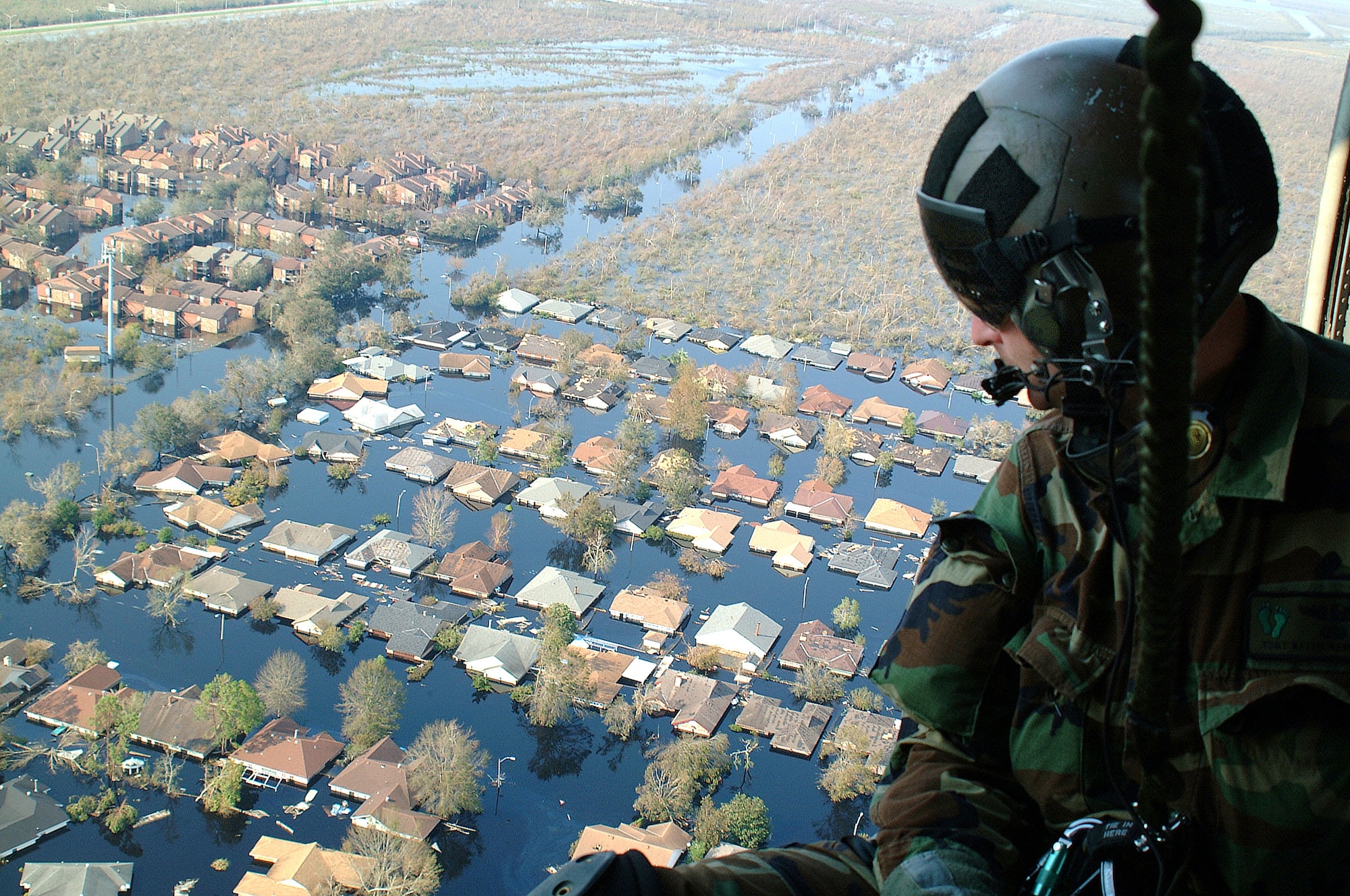 OVER NEW ORLEANS -- Tech. Sgt. Keith Berry looks down into flooded streets searching for survivors.  He is part of an Air Force Reserve team credited with saving more than 1,040 people in the aftermath of Hurricane Katrina.  He is a pararescueman with the 304th Rescue Squadron from Portland, Ore.  (U.S. Air Force photo by Master Sgt. Bill Huntington)