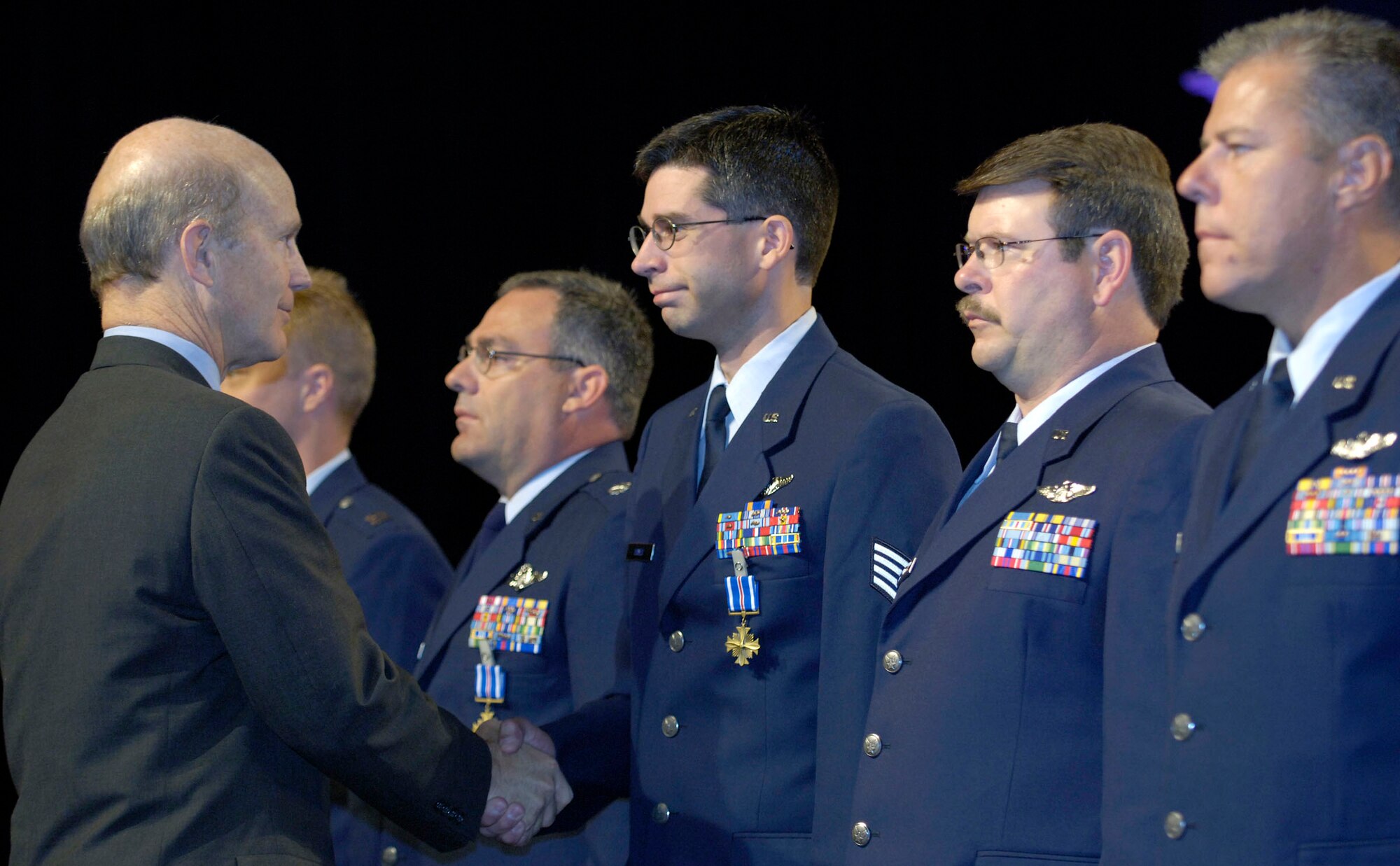 WASHINGTON -- Acting Secretary of the Air Force Pete Geren congratulates flight engineer Staff Sgt. Daniel Hayes after awarding him the Distinguished Flying Cross during the opening ceremonies of the 2005 Air and Space Conference and Technology Exposition here Sept. 12.  Staff Sgt. Hayes and his fellow crewmembers earned the cross for distinguished service during an Operation Iraqi Freedom counterinsurgency sustainment mission Oct. 26, 2004.  (U.S. Air Force photo by Master Sgt. Jim Varhegyi)