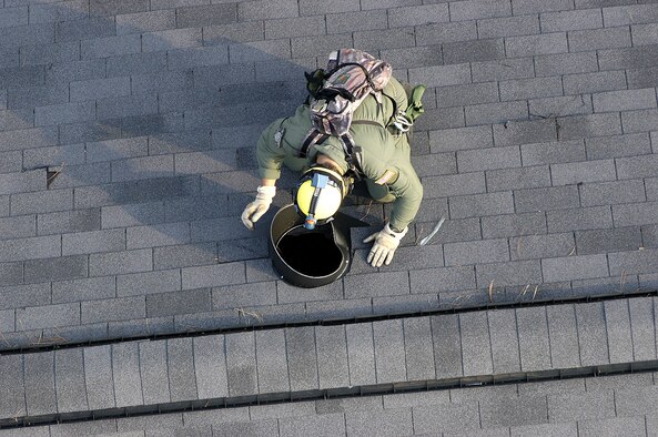 NEW ORLEANS -- Tech. Sgt. Paul Schultz shouts down an airshaft on a flooded house as he checks out a lead that there may still be people trapped inside.  He is a reservist with the 306th Rescue Squadron from Davis-Monthan Air Force Base, Ariz.  (U.S. Air Force photo by Senior Master Sgt. Elaine Mayo)
