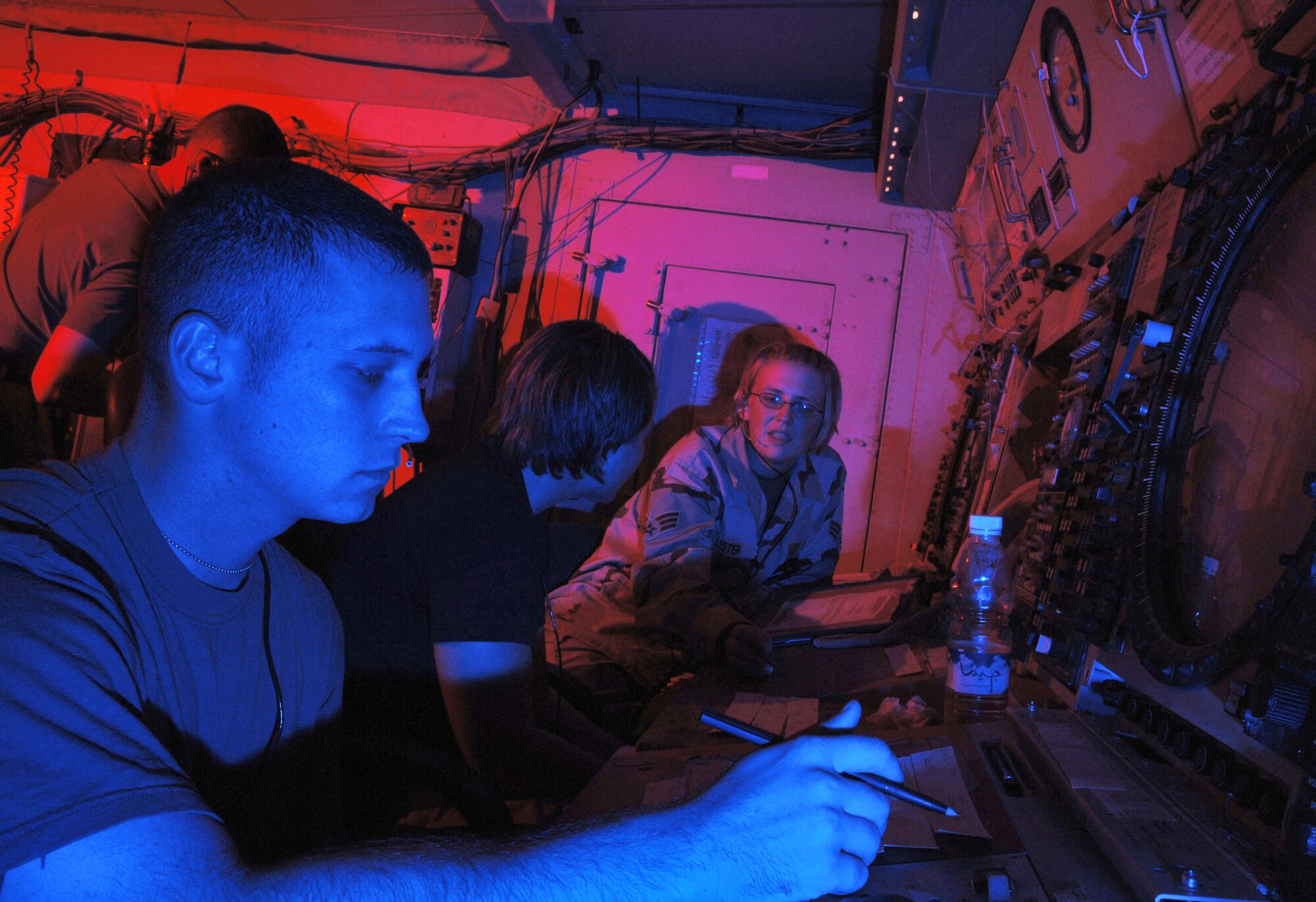 ALI BASE, Iraq -- (Left to right) Senior Airman Paul Oceanak monitors the radar scope while Senior Airman Megan Lister teaches Senior Airman Bobbie Tenney how to juggle both civil and combat air traffic. Putting fighters on target is a first for the crew of controllers who direct airplane traffic within 50,000 square miles surrounding Ali Base. The three Airmen are area control center controllers with the 407th Expeditionary Operations Support Squadron. (U.S. Air Force photo by Master Sgt. Maurice Hessel)