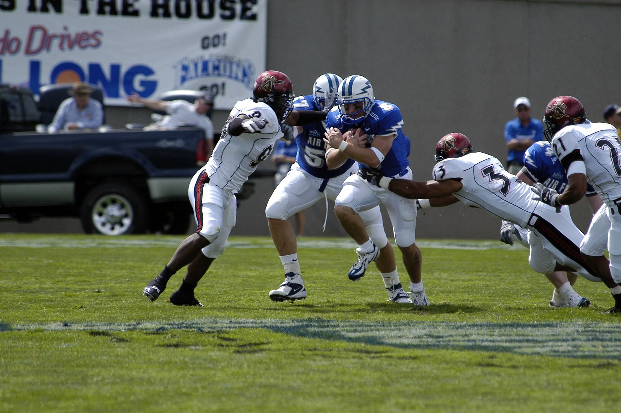 U.S. AIR FORCE ACADEMY, Colo. -- Falcon quarterback Shaun Carney protects the ball as he tries to avoid San Diego State University Aztecs Antwan Applewhite, 93, and Freddy Keiaho, 33.  The sophomore signal-caller ran for 81 yards and passed for another 231.  The Falcons beat the Aztecs 41-29.  (U.S. Air Force photo by 2nd Lt. John Ross)
