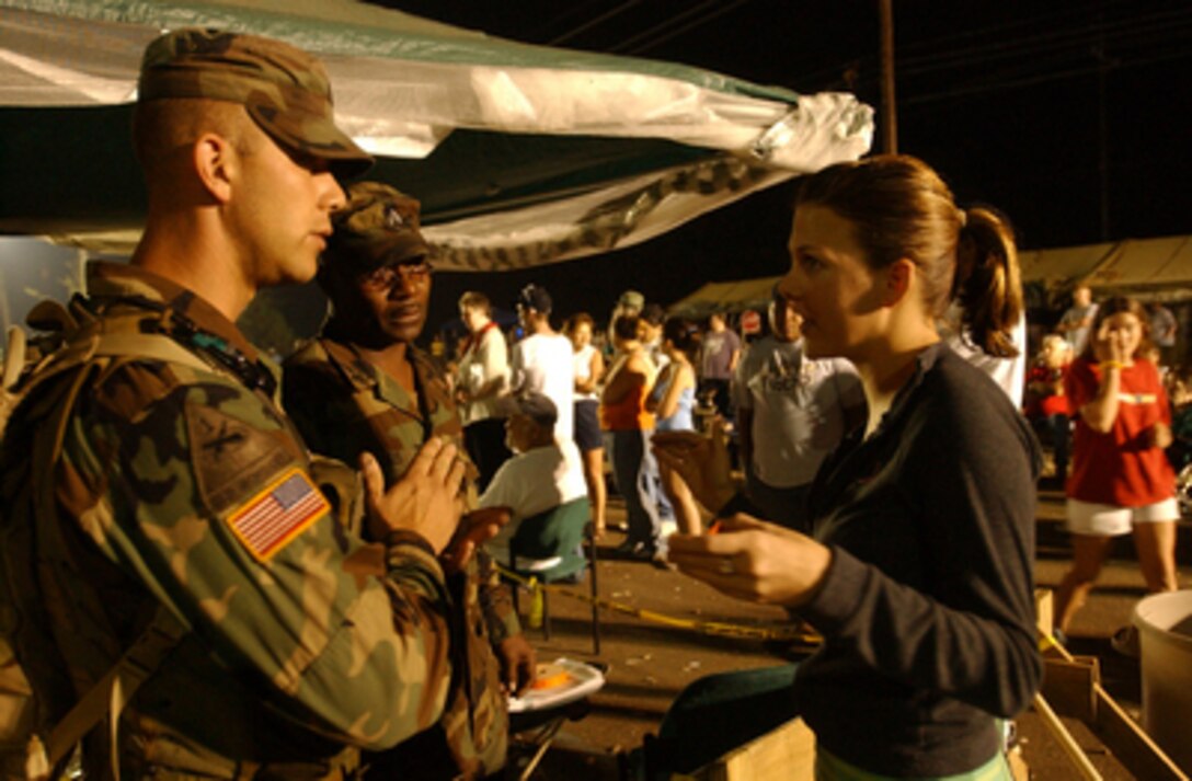 Sgt. Robert Shook (left) gives information to an evacuee from New Orleans, La., on Sept. 9, 2005. Department of Defense units are mobilized as part of Joint Task Force Katrina to support the Federal Emergency Management Agency's disaster relief efforts in the Gulf Coast areas devastated by Hurricane Katrina. Shook is assigned to the North Carolina National Guard's 113th Quick Response Force. 